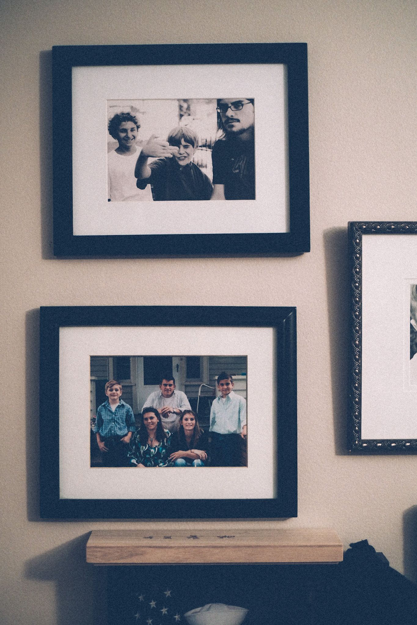 A wall of family photos, framed, various sizes.