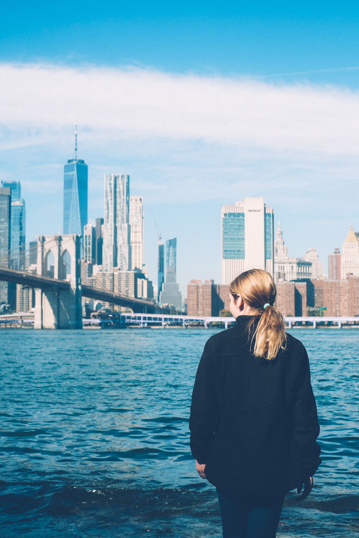 A girl looks out at the river, toward downtown Manhattan.