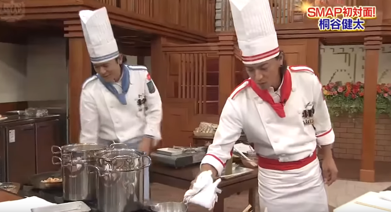 Image of Kitaro Shingo and Kimura Takuya holding frying pans on a working stove on the SMAPxSMAP set