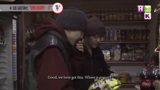 Image of Ace and AZ in a small convenience store, finding drinkable yogurt in a refrigerated display case