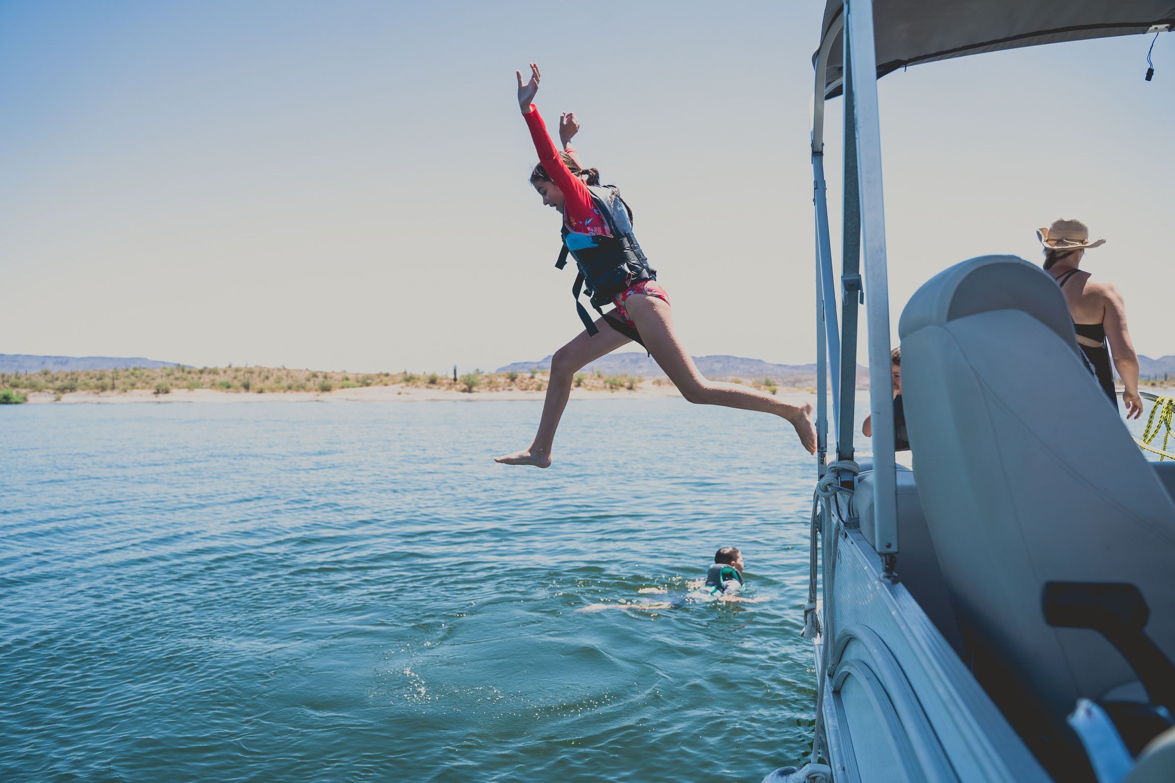 Hannah jumping from the boat into the lake in Arizona
