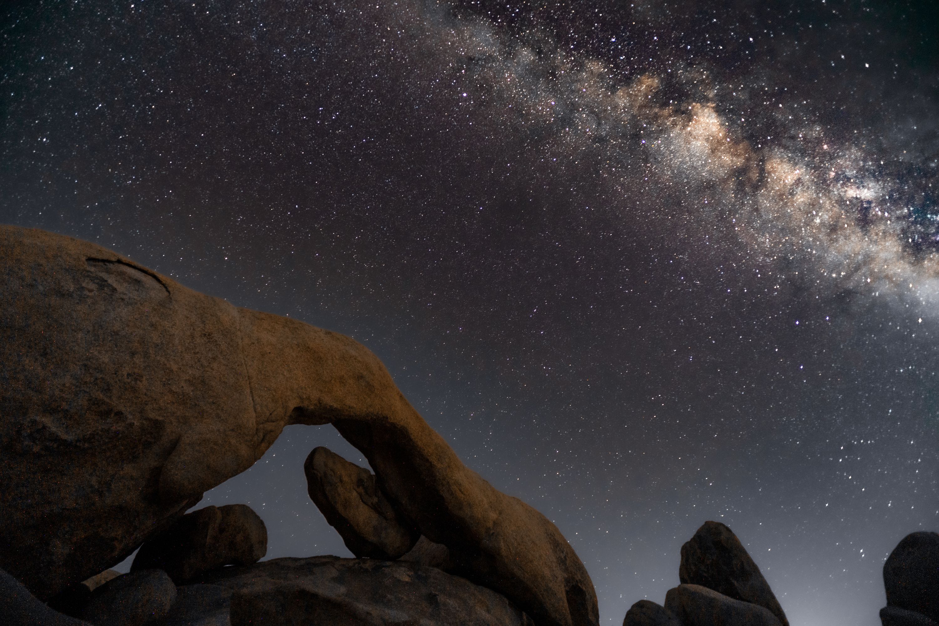 The milky way with arch rock in the distance