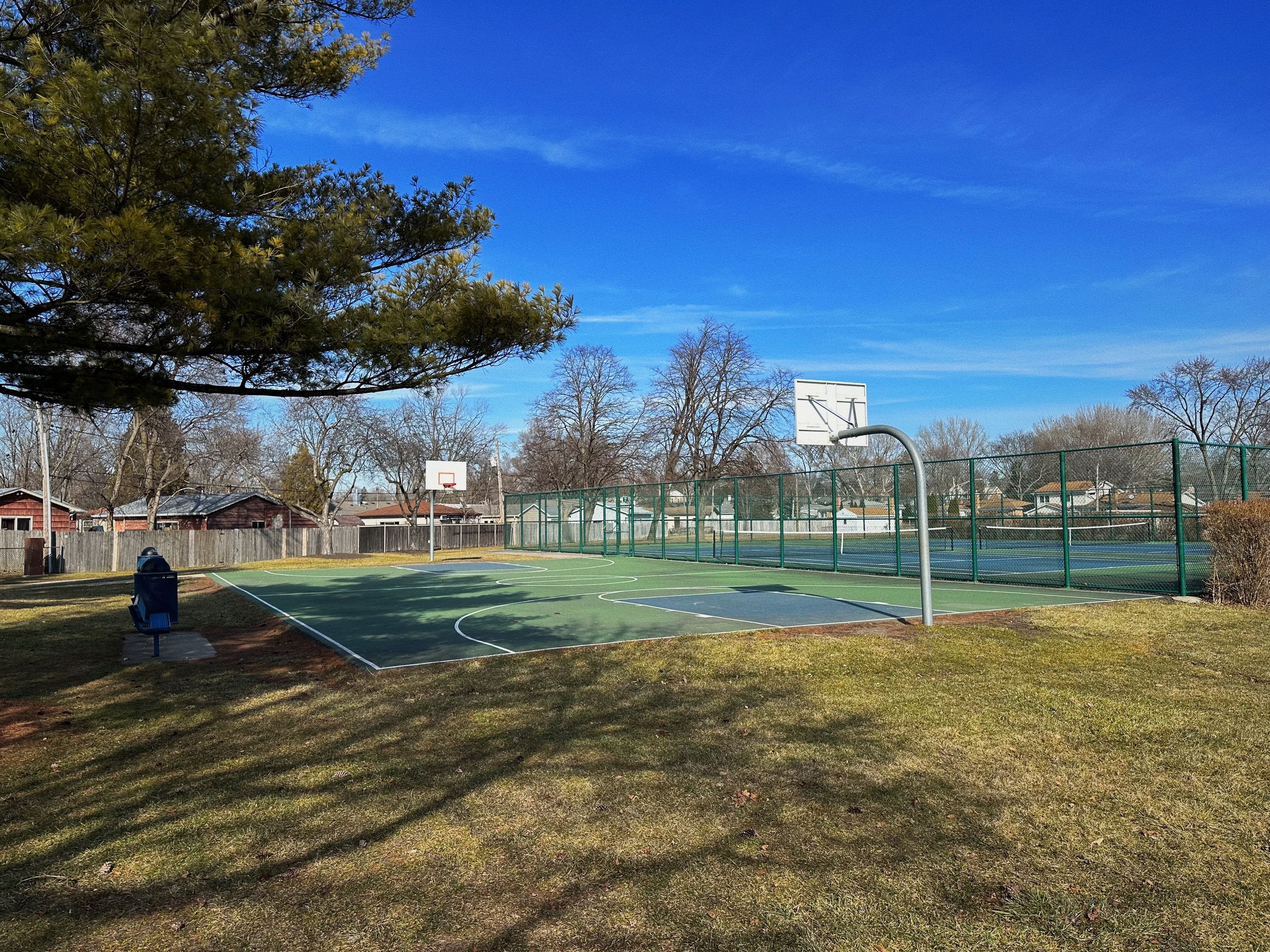 Picture of basketball court with blue sky with clouds