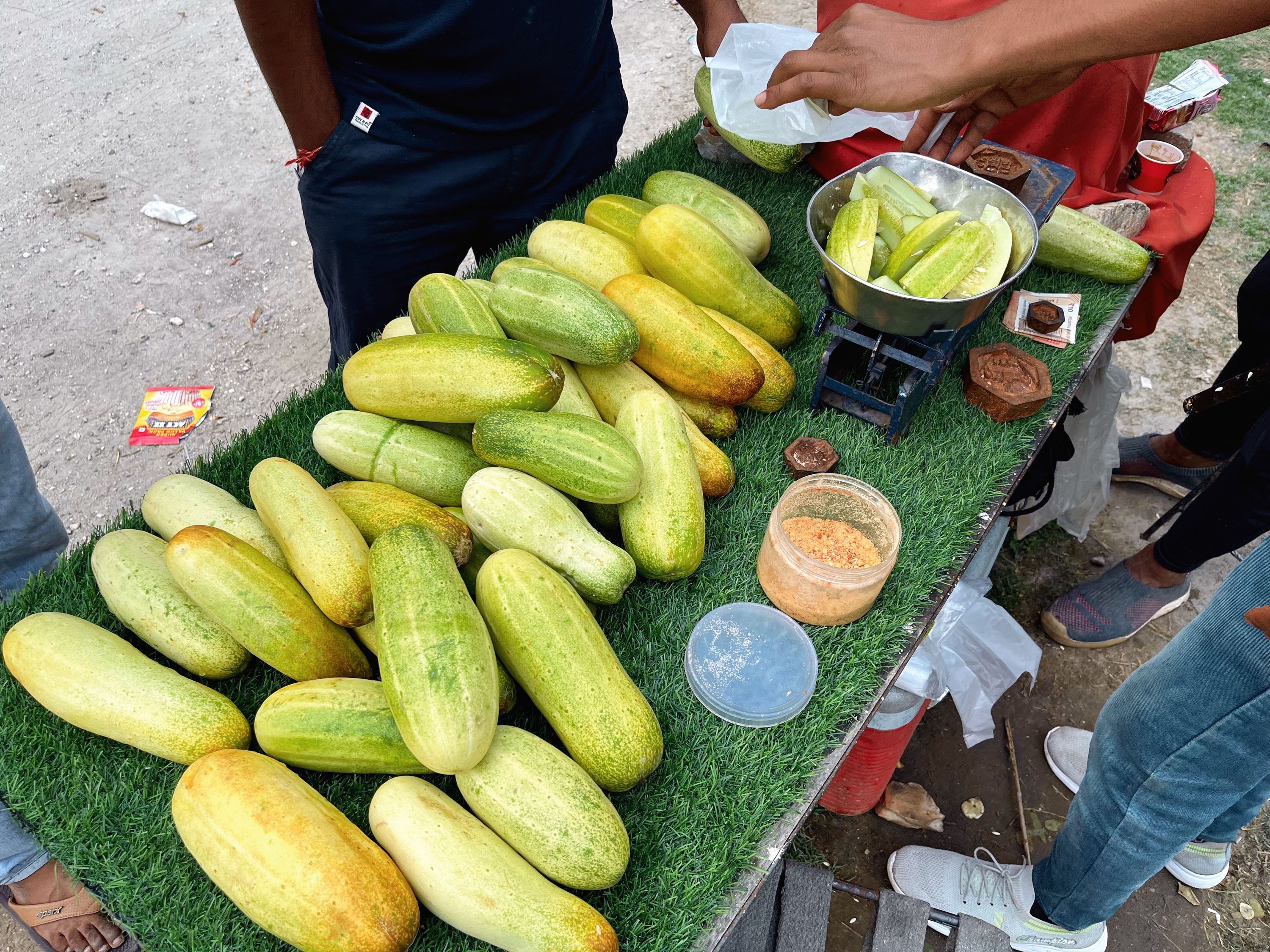 Cucumber seller on the Gangotri road near Uttarkashi, Uttarakhand, India. June 2022.