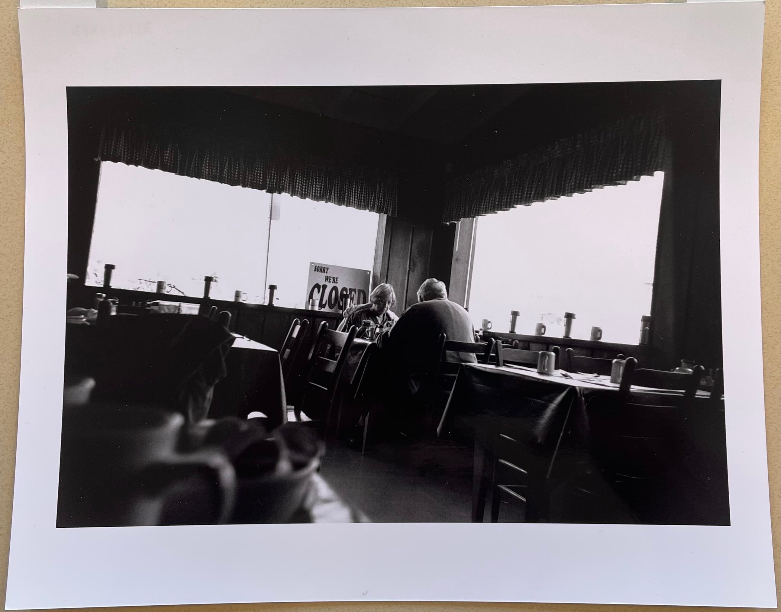 A glossy paper print of a black and white image of an older couple eating breakfast at Joey’s Pancake House in Maggie Valley, North Carolina