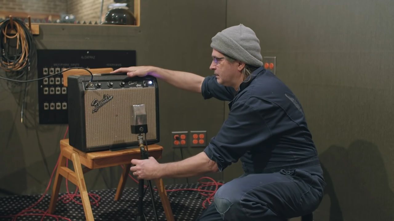 Steve Albini placing a mic in front of an amp cabinet in the studio