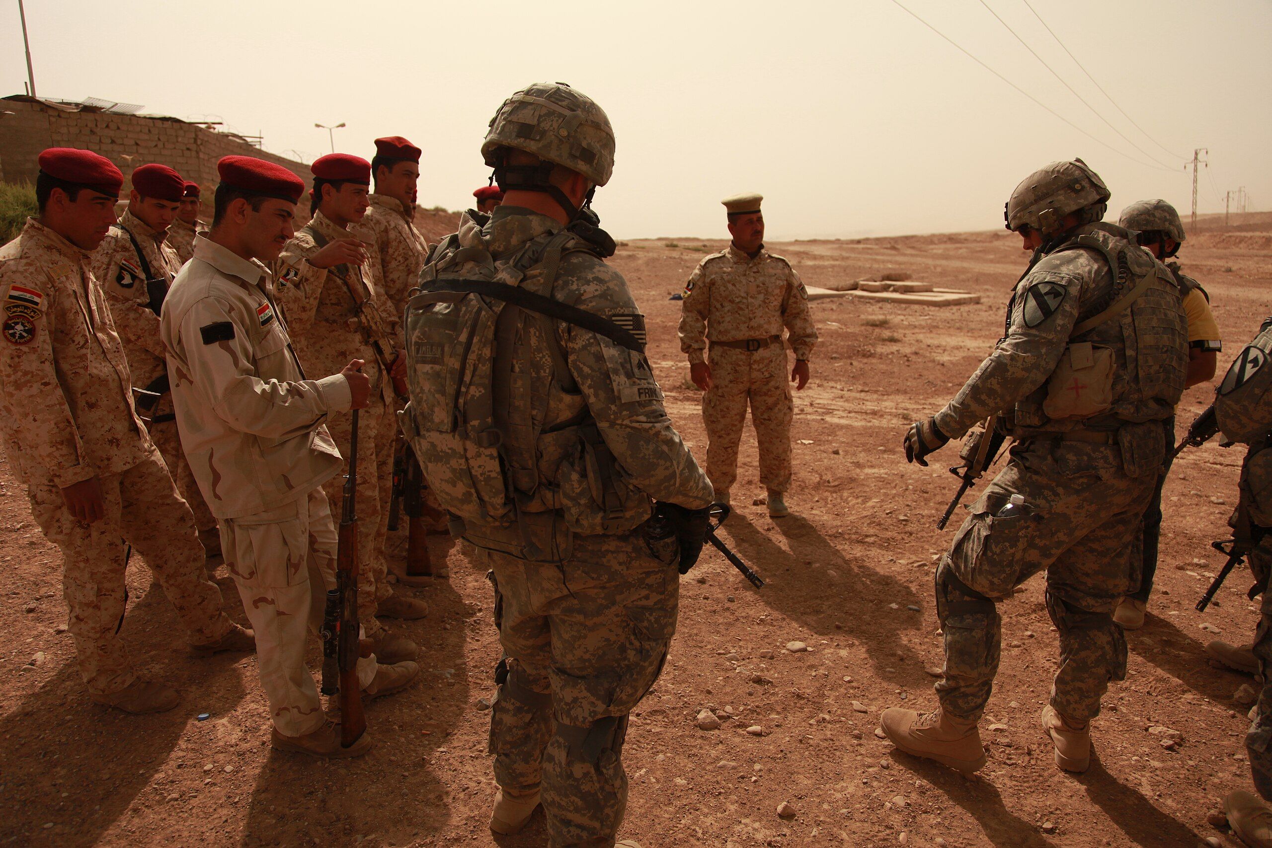 U.S. Army Spc. Jack Marage, from Clear Lake, Calif., assigned to 4th Battalion, 9th Cavalry, 2nd Brigade Combat Team, 1st Cavalry Division, teaches a class about types of patrols at the 15th Iraqi army compound in Kirkuk, Iraq, Oct. 10, 2009. DVIDS, Wikimedia Commons.