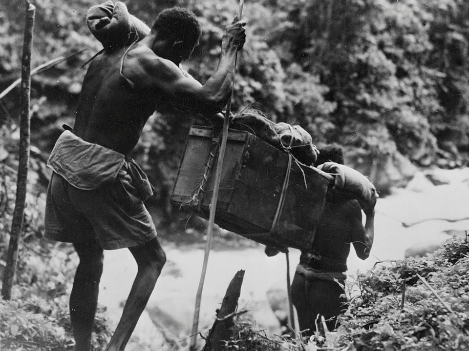 Porters heft Allied supplies through the jungles of New Guinea. Image courtesy of the Library of Congress.