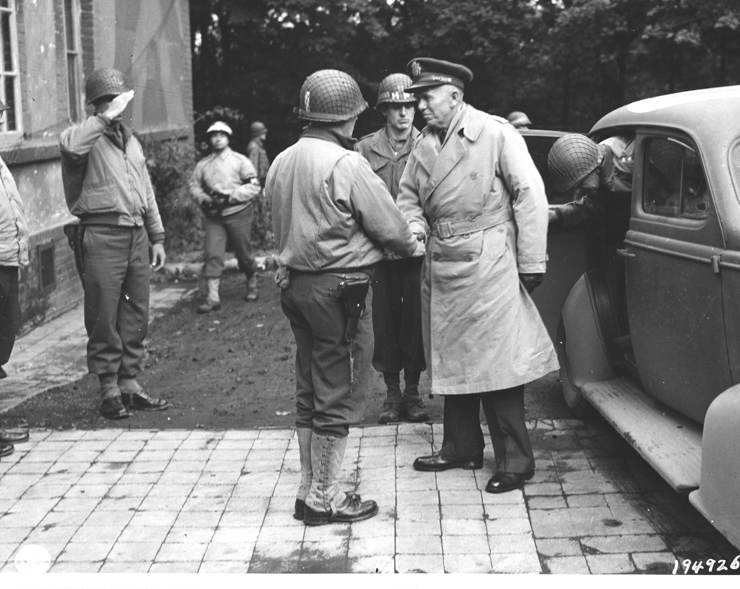 Maj. Gen. Norman D. Cota greets General George C. Marshall, U.S. Chief of Staff, on Gen. Marshall’s arrival at a headquarters in Belgium, 10/22/44. 28th Division, Elsenborn, Belgium. Wikimedia Commons.
