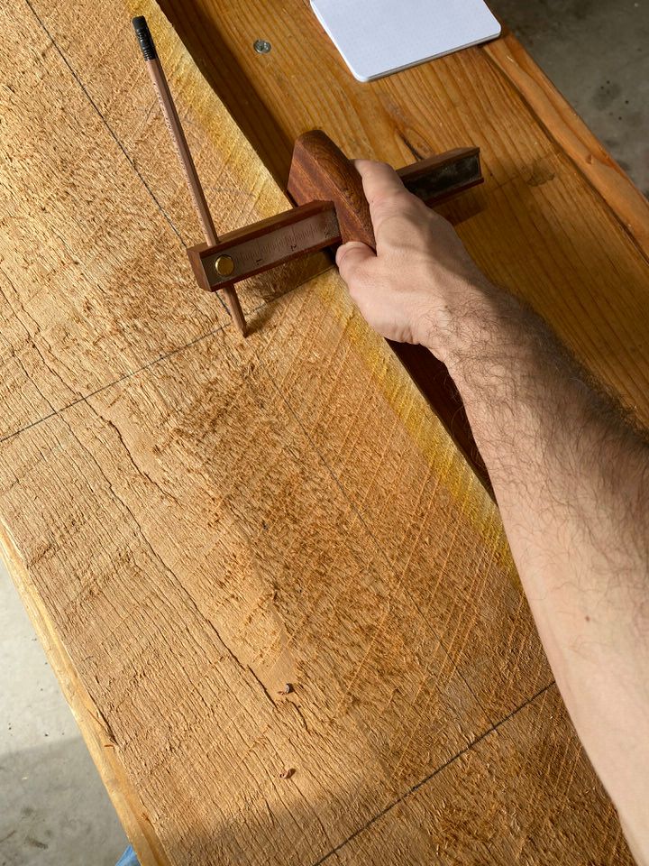Marking gauge being used to mark out various parts of a project on a dimensioned cherry board.