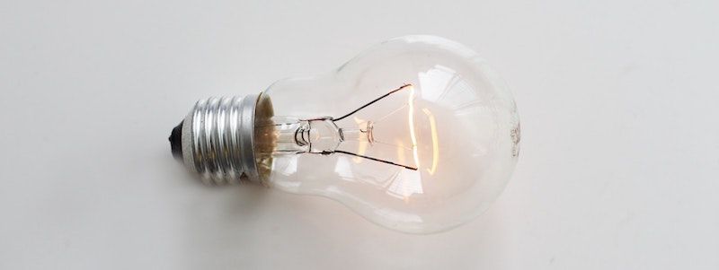 Lit incandescent lightbulb on a white background