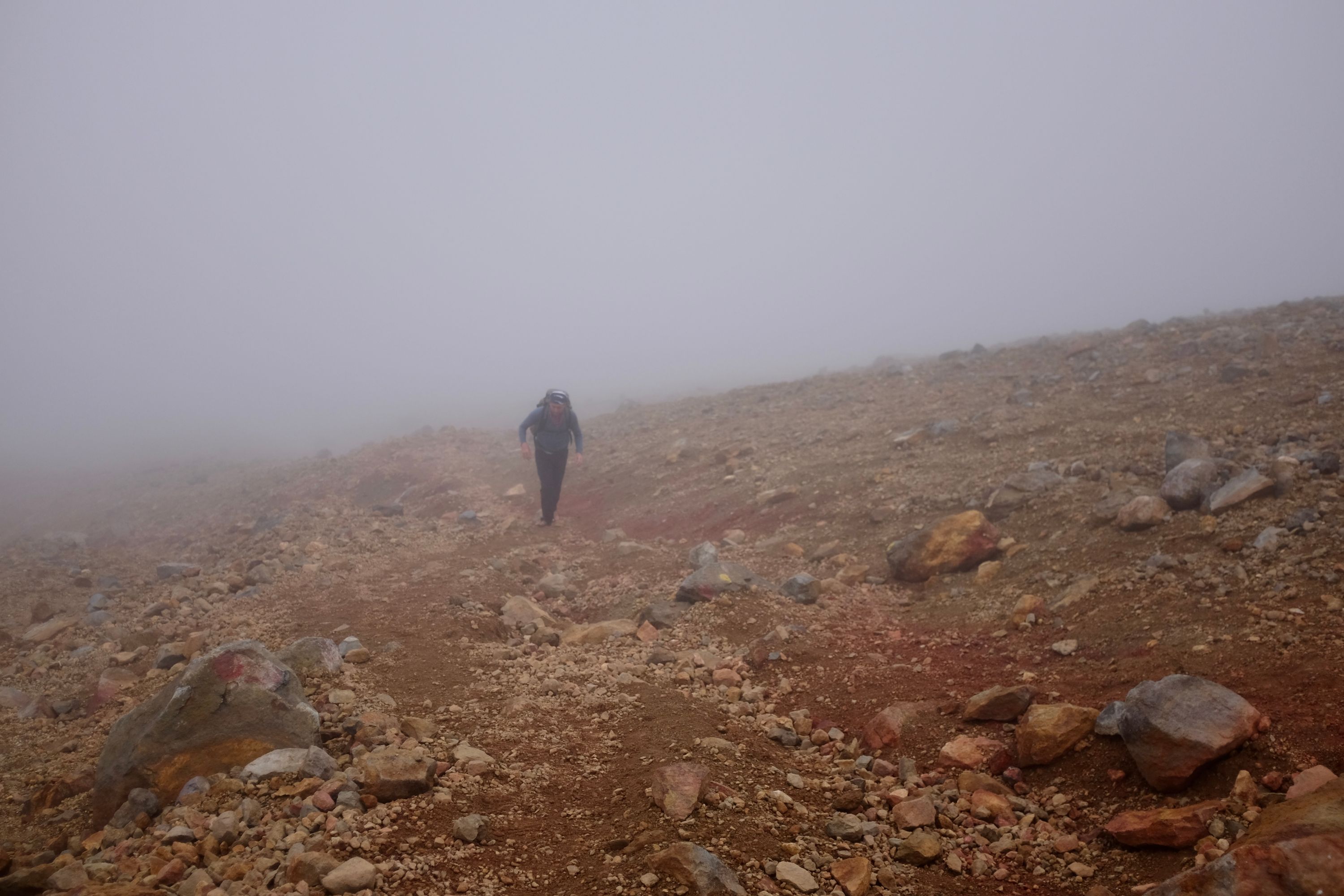 Gabor ascends an orange-brown scree slope.