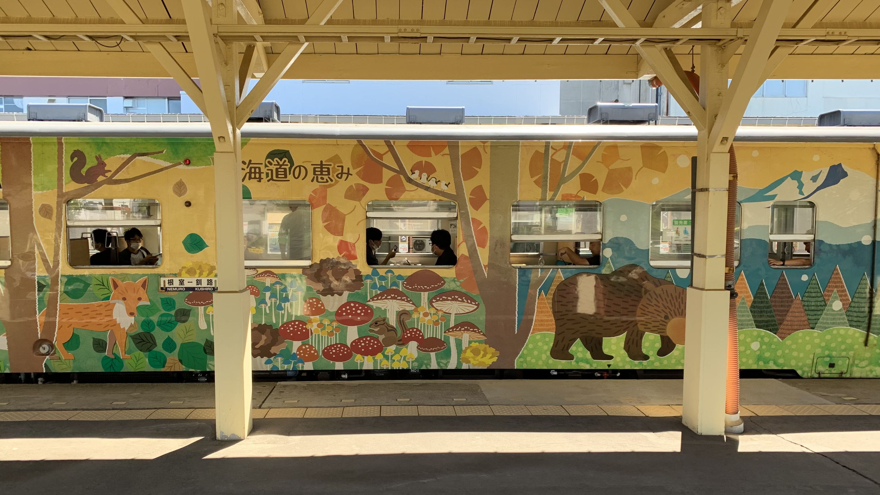 A yellow train decorated with forest animals.