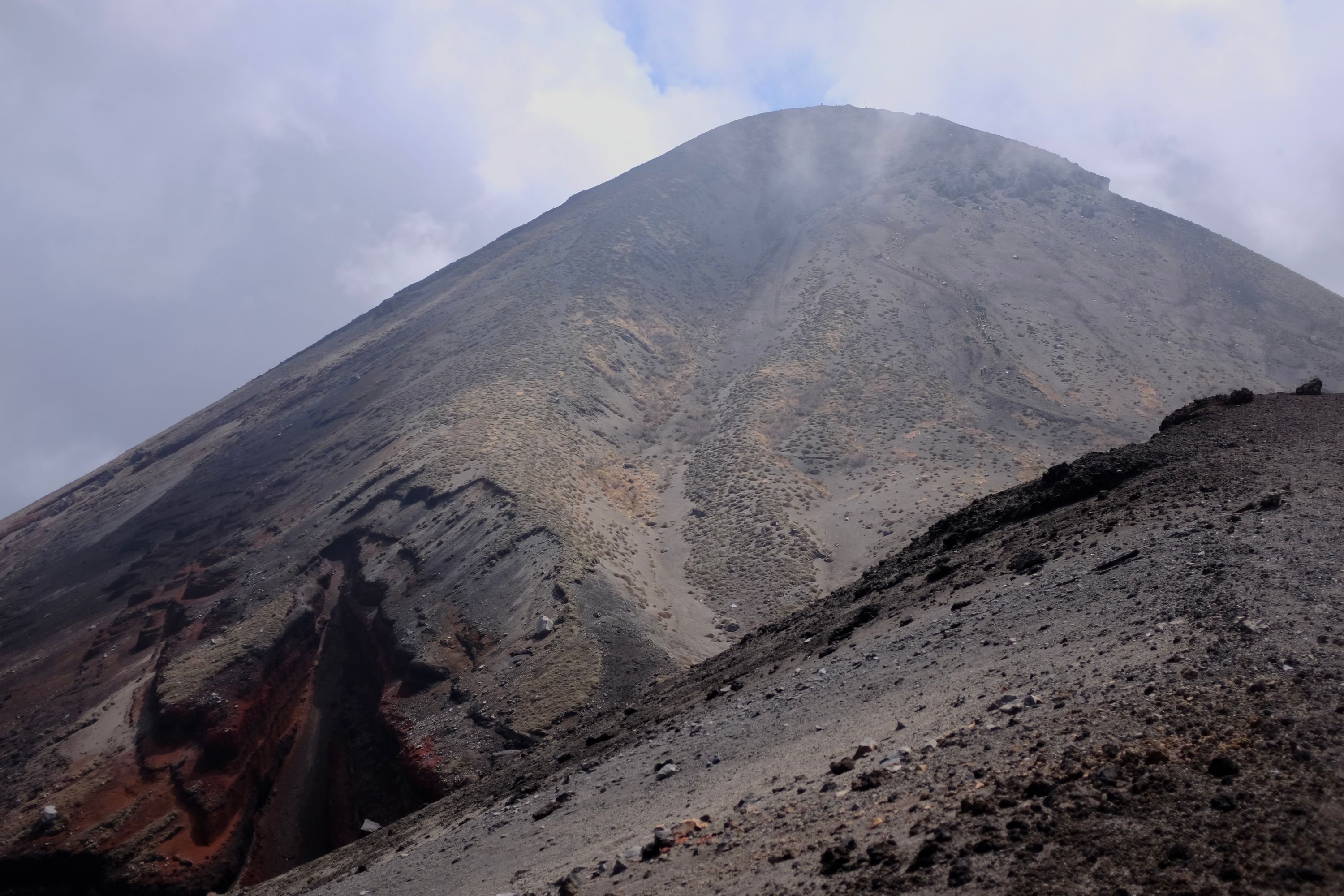 A thin, long line of soldiers climbing up the slope of a volcano, Takachiho-no-mine, seen from quite far away.