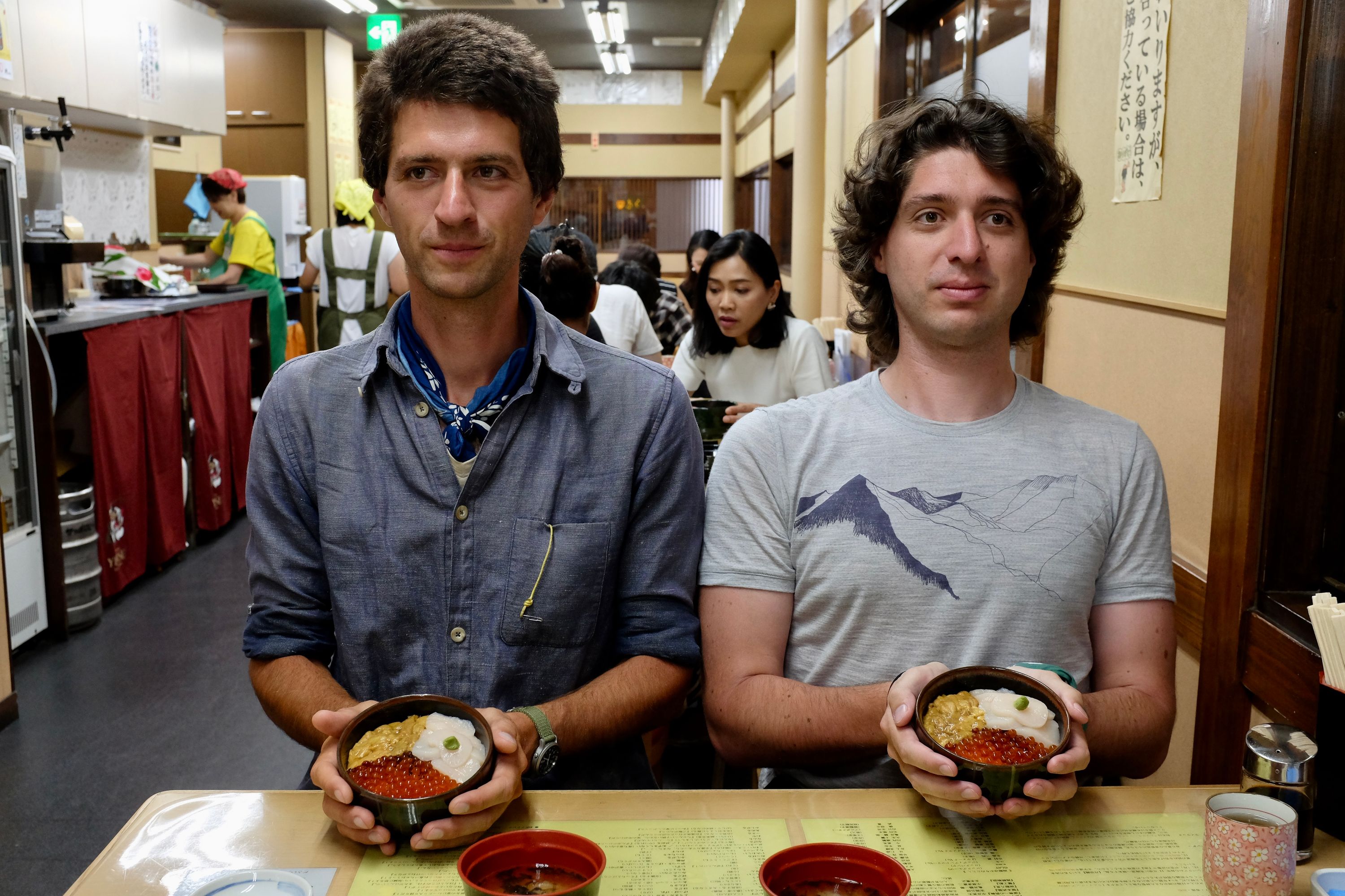 The author and Gabor pose with two bowls of seafood in a restaurant.