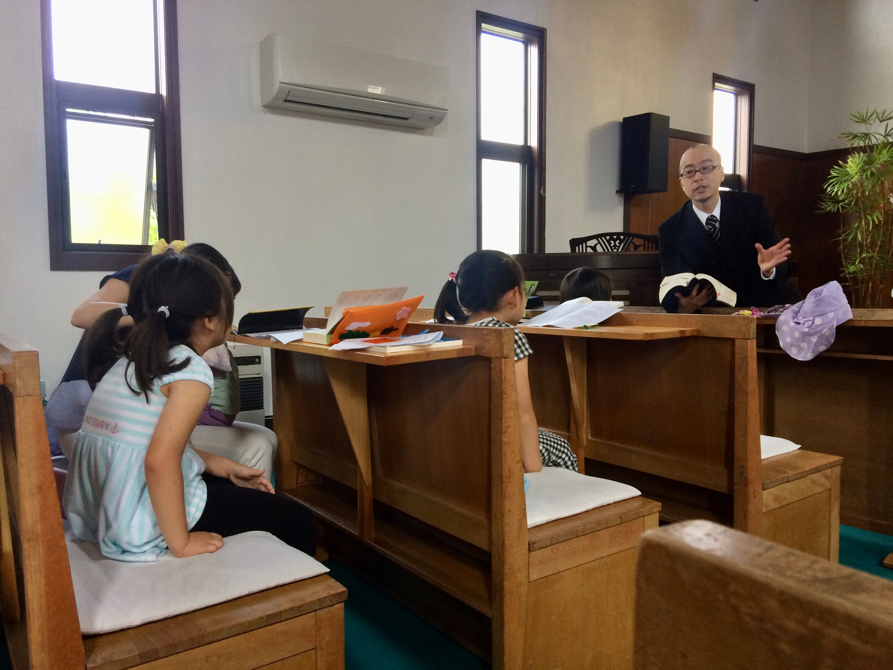 Small children in a church, dwarfed by the benches.