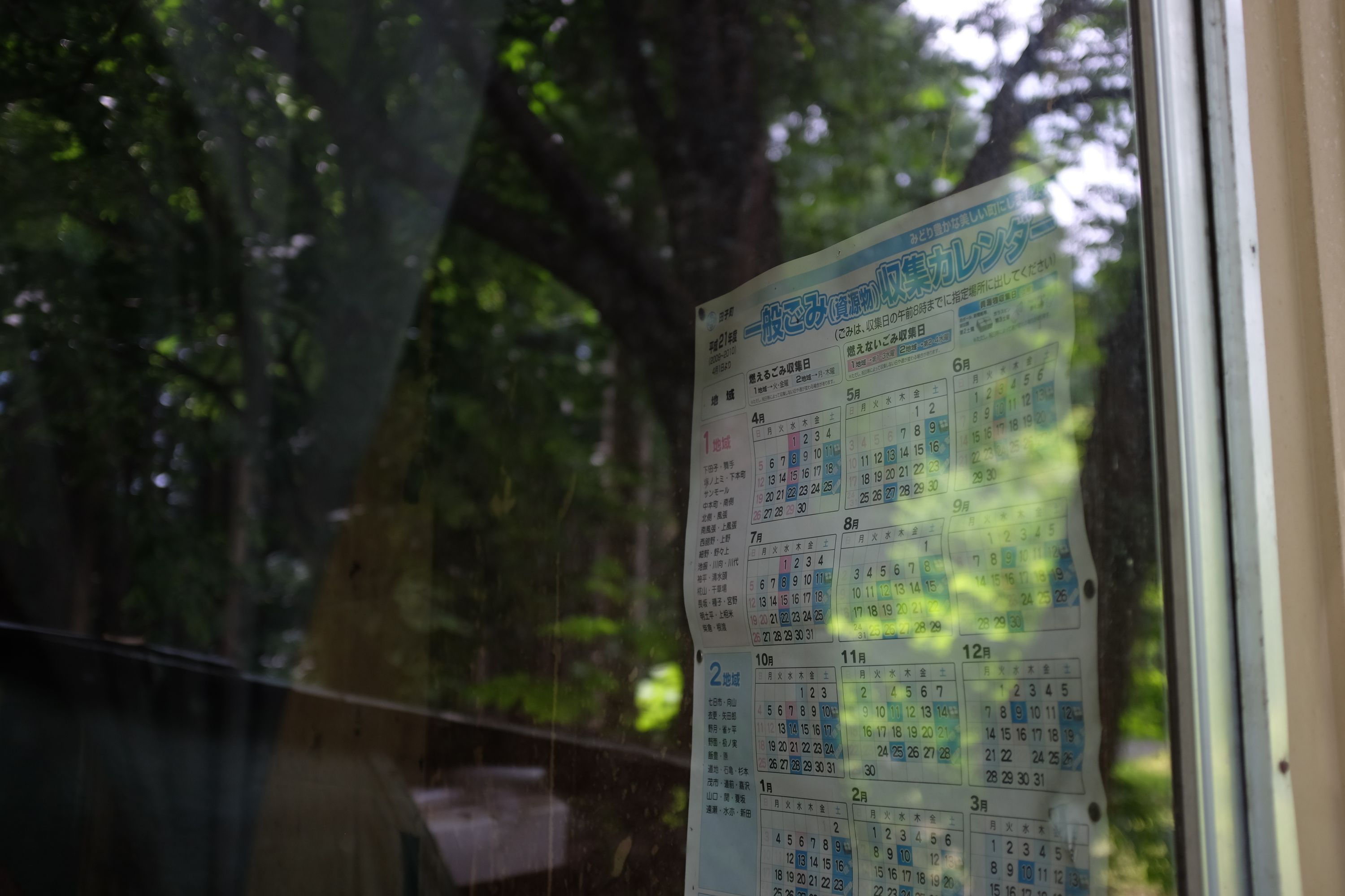 A wall calendar from the year 2009 seen through a window.