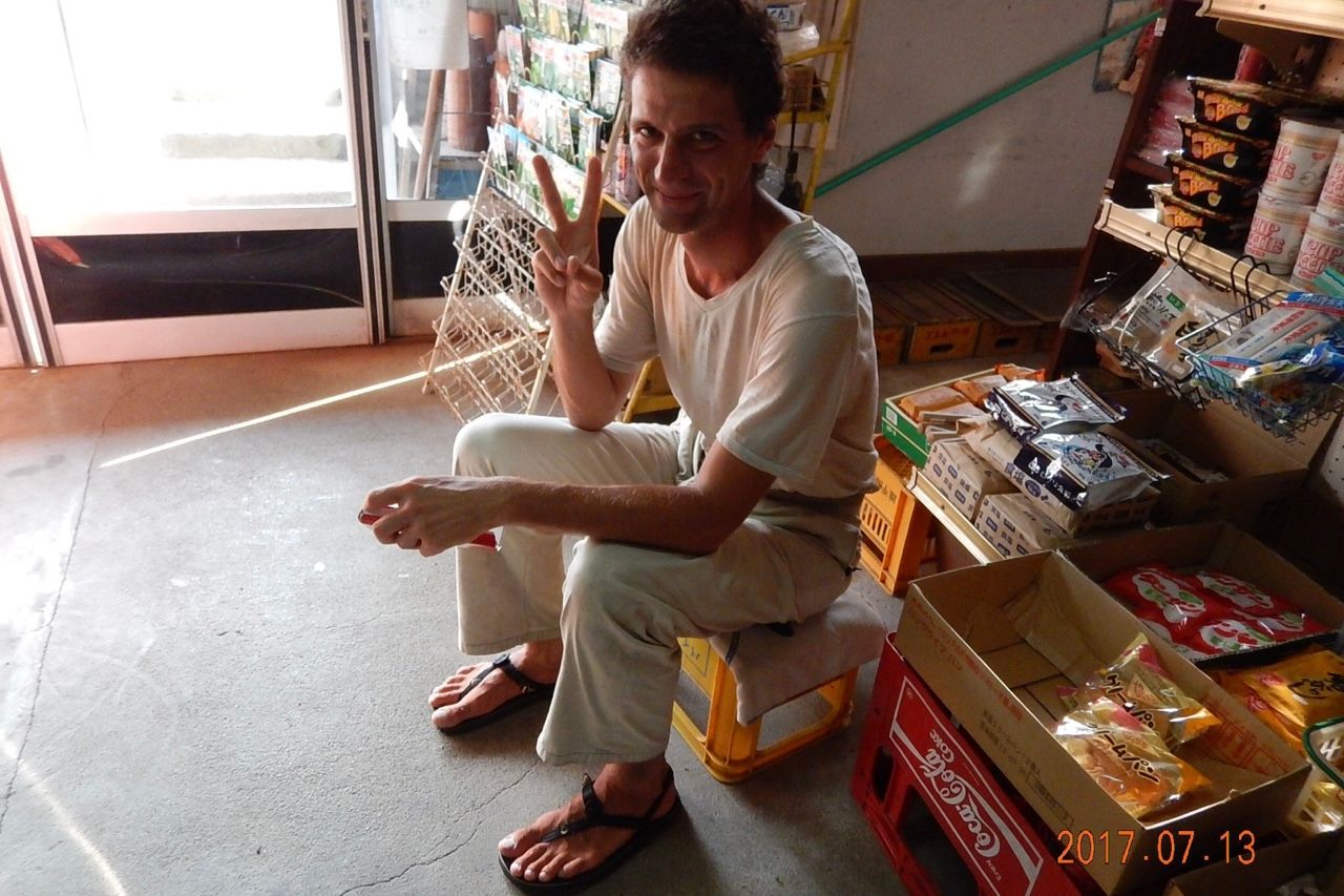 The author sits on a beer crate and shows the V sign in return.