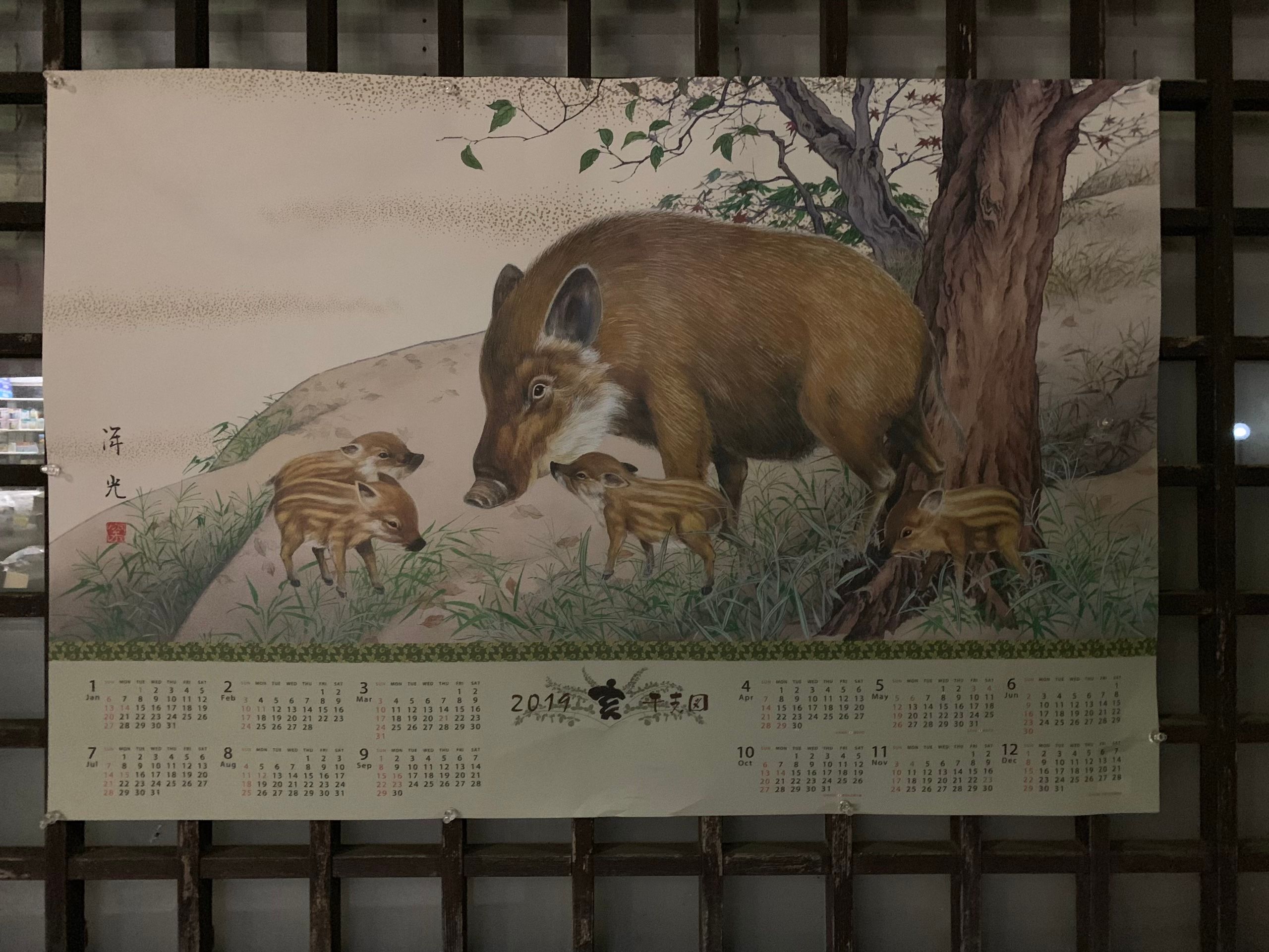 A 2019 wall calendar with a painting of a wild boar and three piglets.