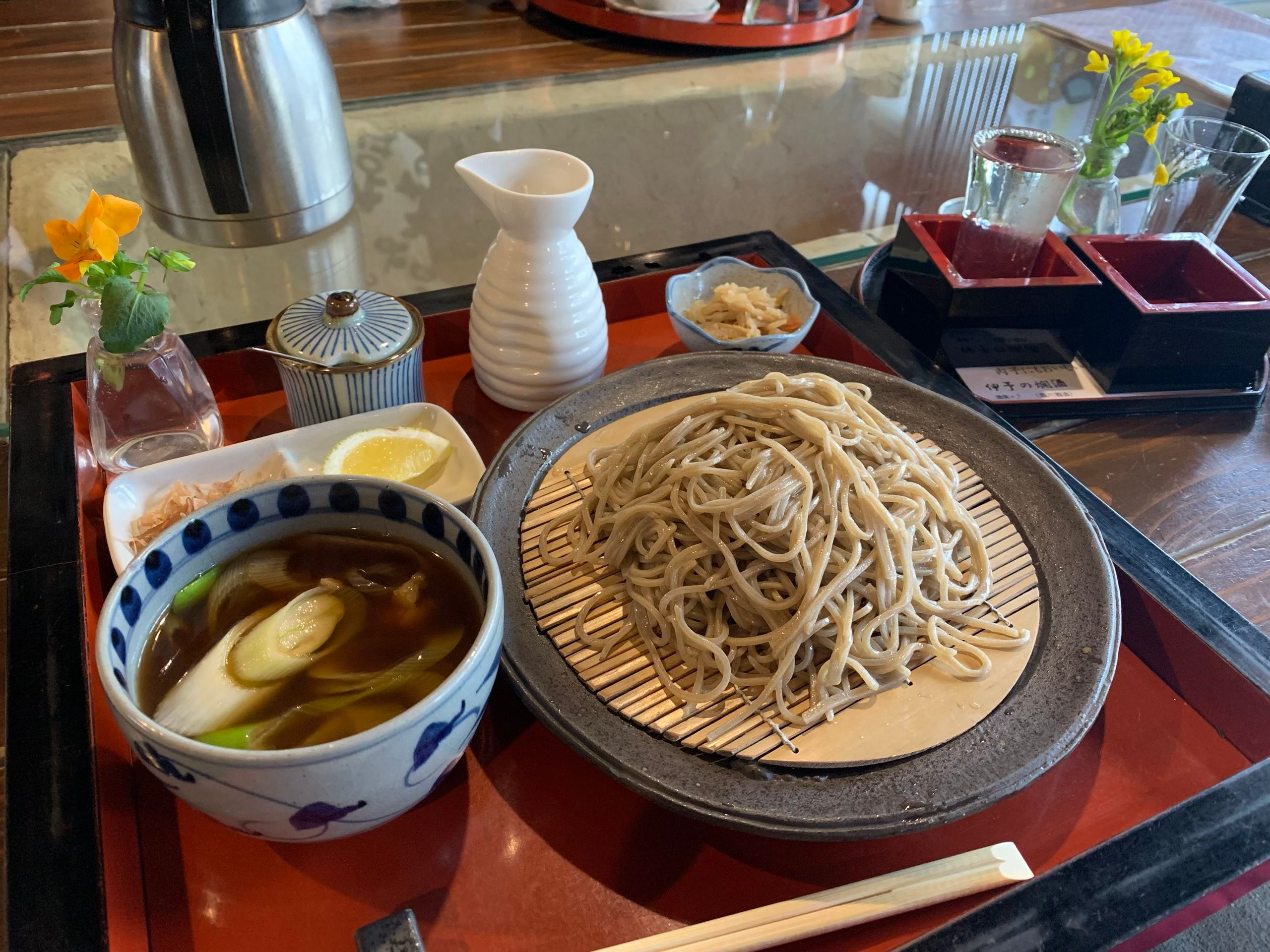 A Japanese meal of buckwheat noodles and vegetable soup on a tray.