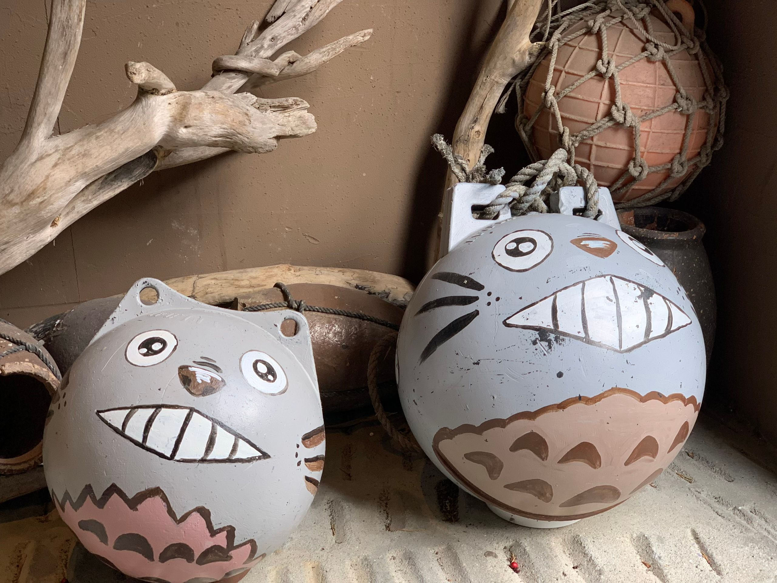 Two fishing buoys painted to resemble totoros.
