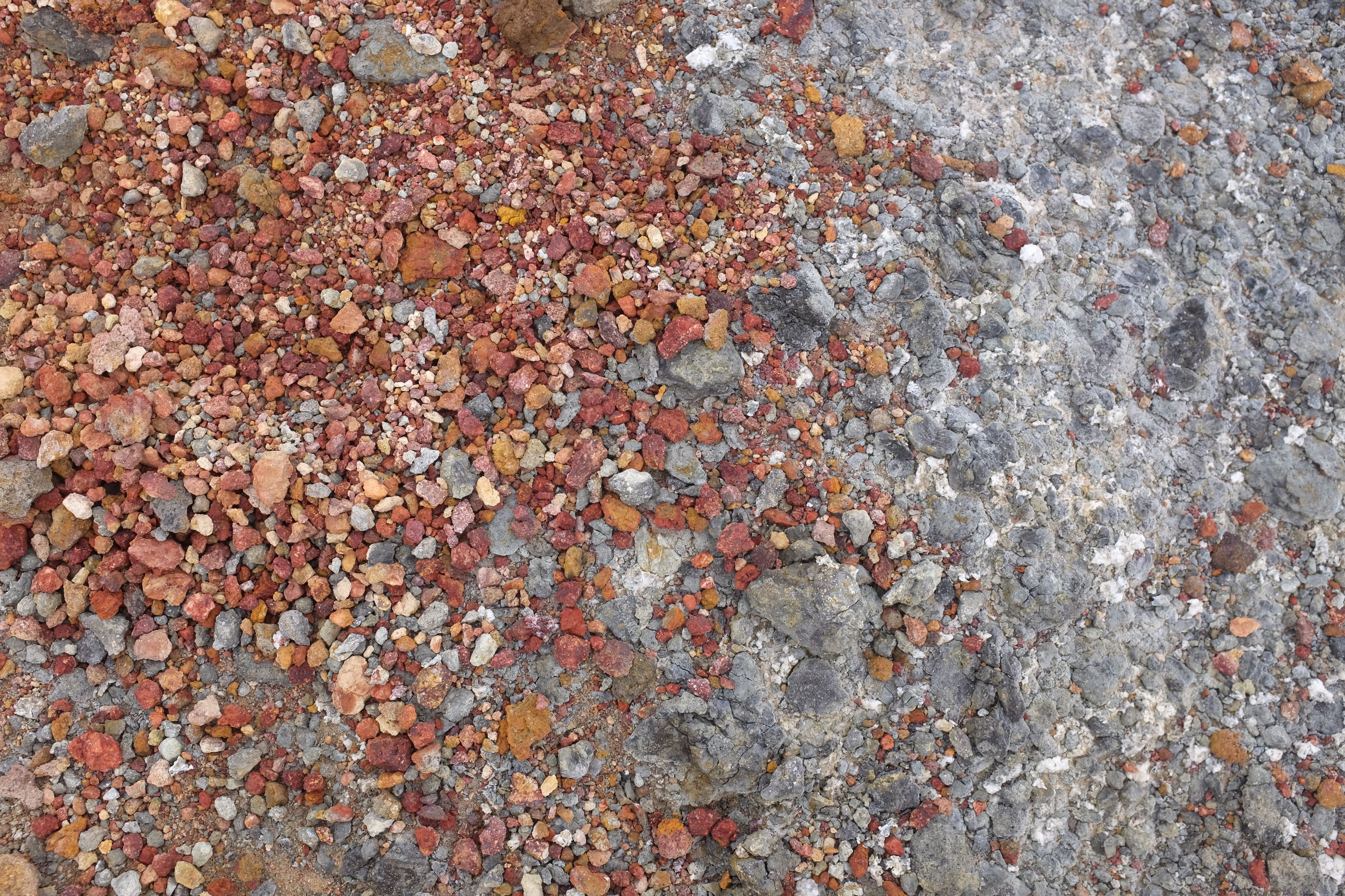 The author holds in his left hand four pieces of M&M’s, which are almost the same color as the volcanic scree.