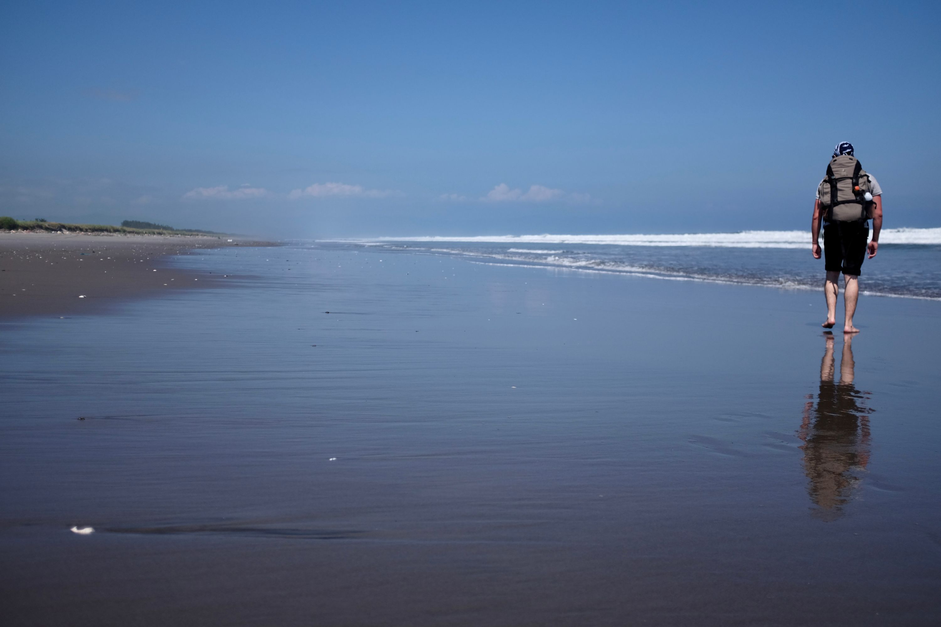 Gabor walks barefoot in the surf.