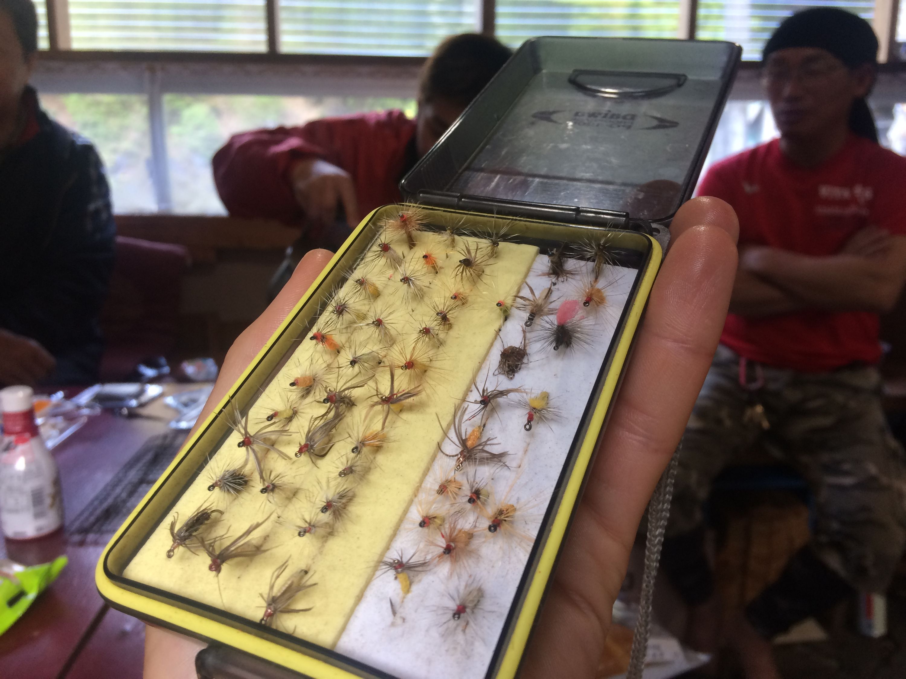 A box of tiny flies used for tenkara, Japanese-style fly-fishing, fits in a single hand.