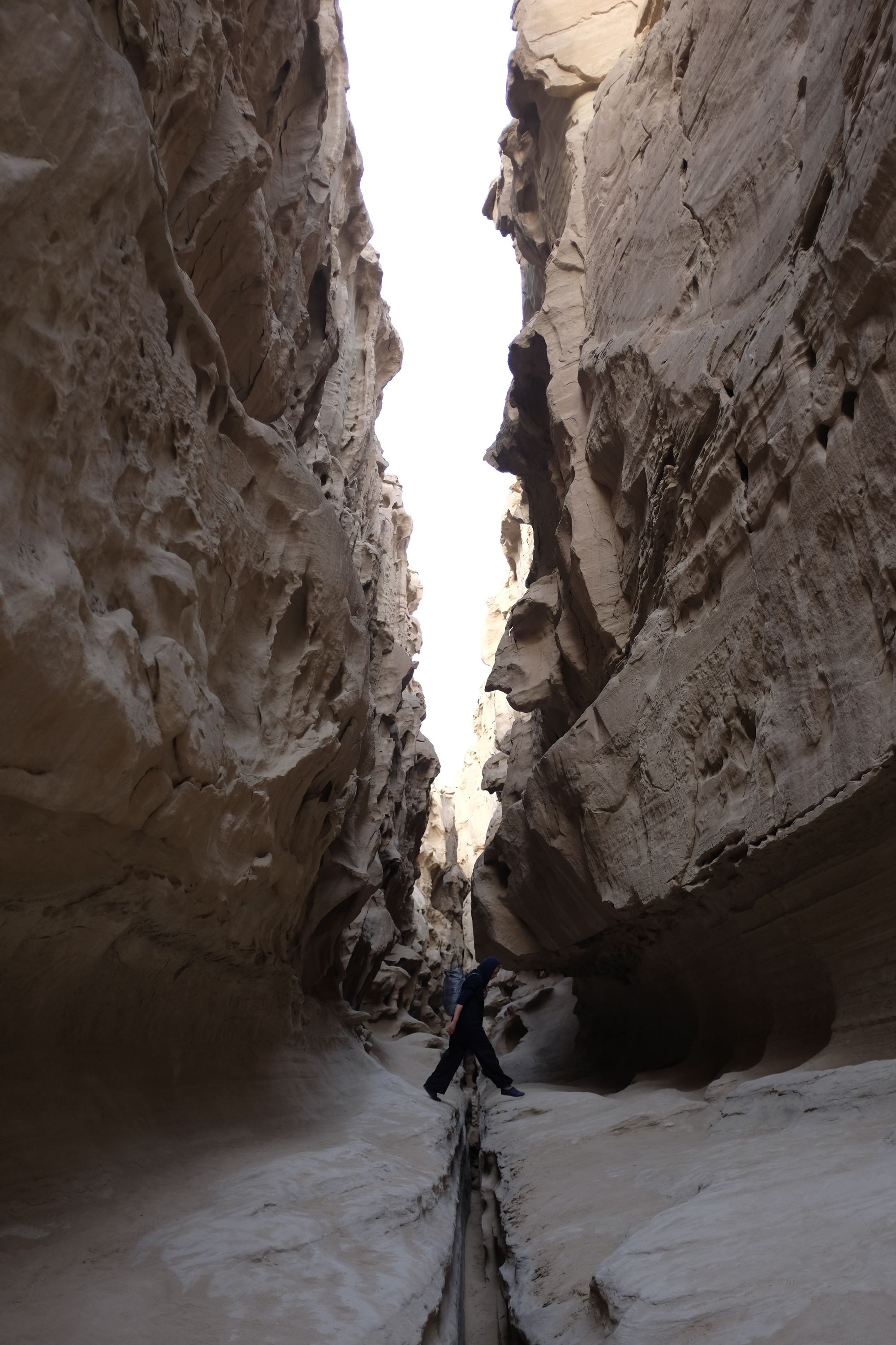 A woman jumps across a canyon barely wider than a human being.