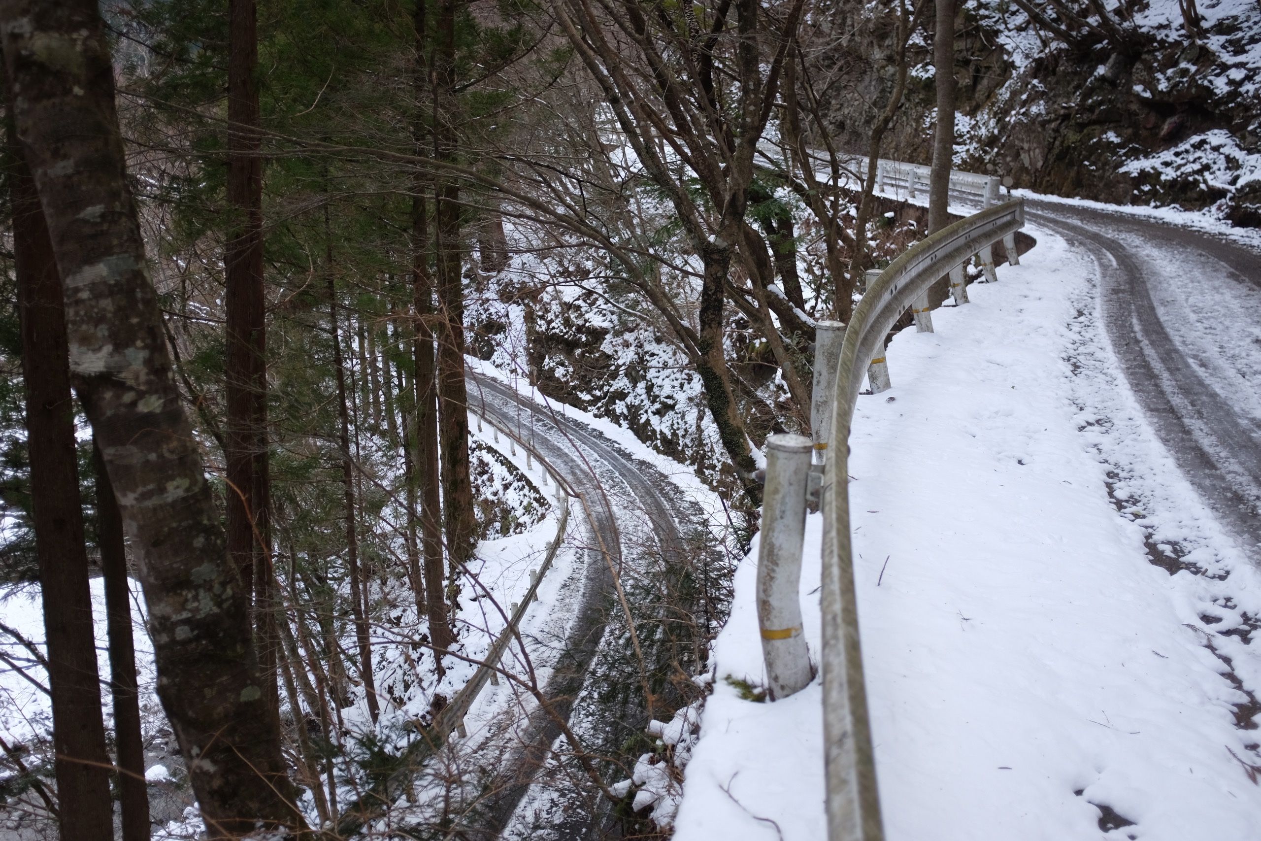 A snow-covered road makes a 180-degree turn.