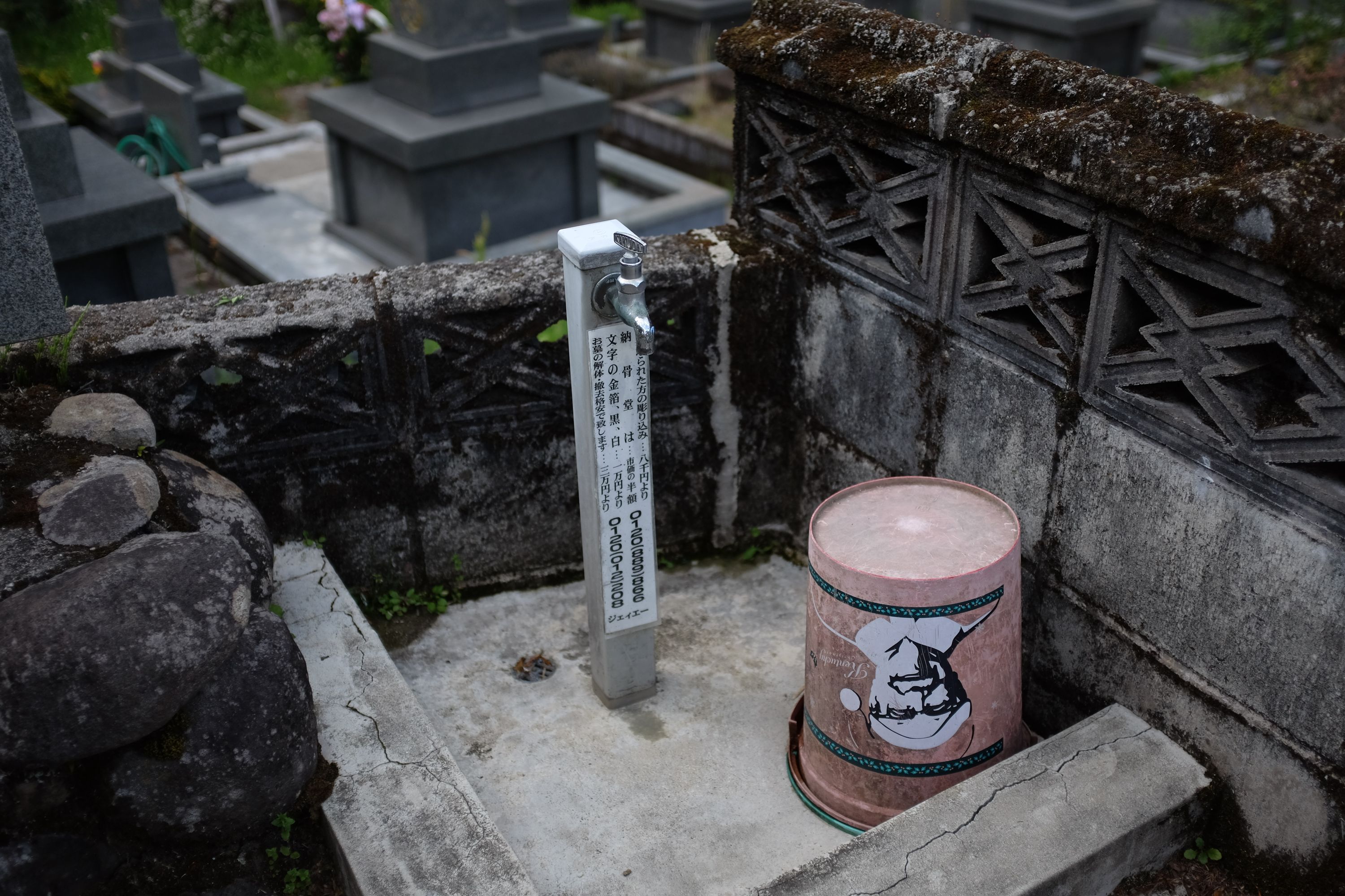 A plastic Kentucky Fried Chicken bucket on a grave.