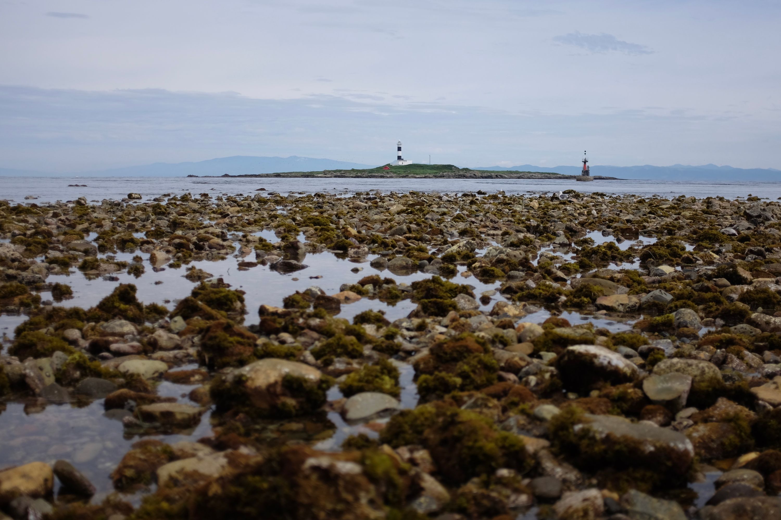 The lighthouse at Cape Ōma, the northern tip of Honshu, viewed from ground level, with Hokkaido on the horizon.