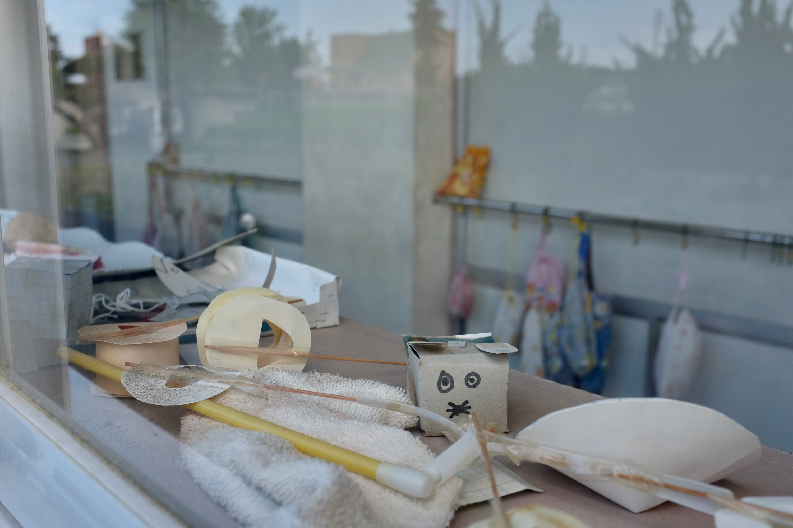 Craft tools and a paper rabbit in a school window.