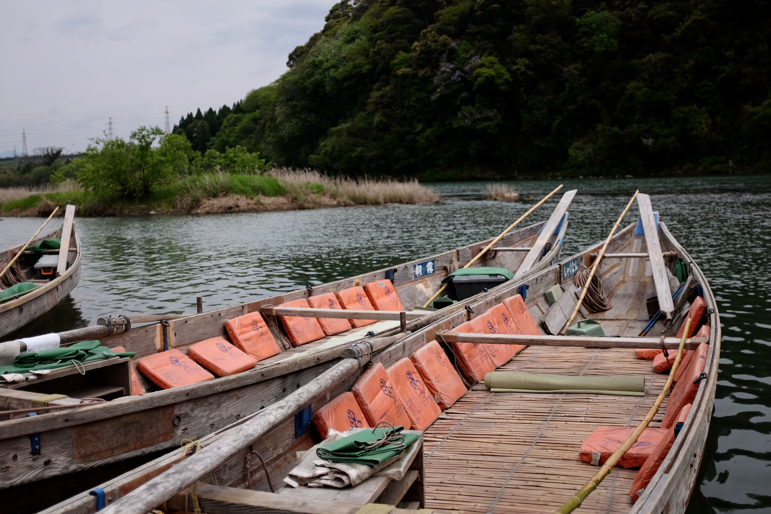 Three old-fashioned boats on a small river.