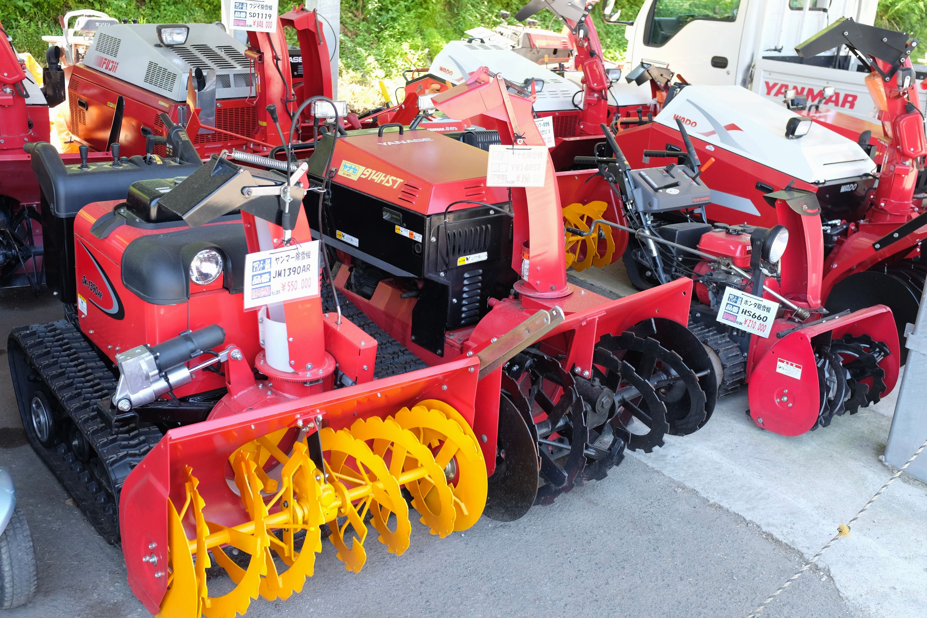Large red and yellow snowplows for sale.