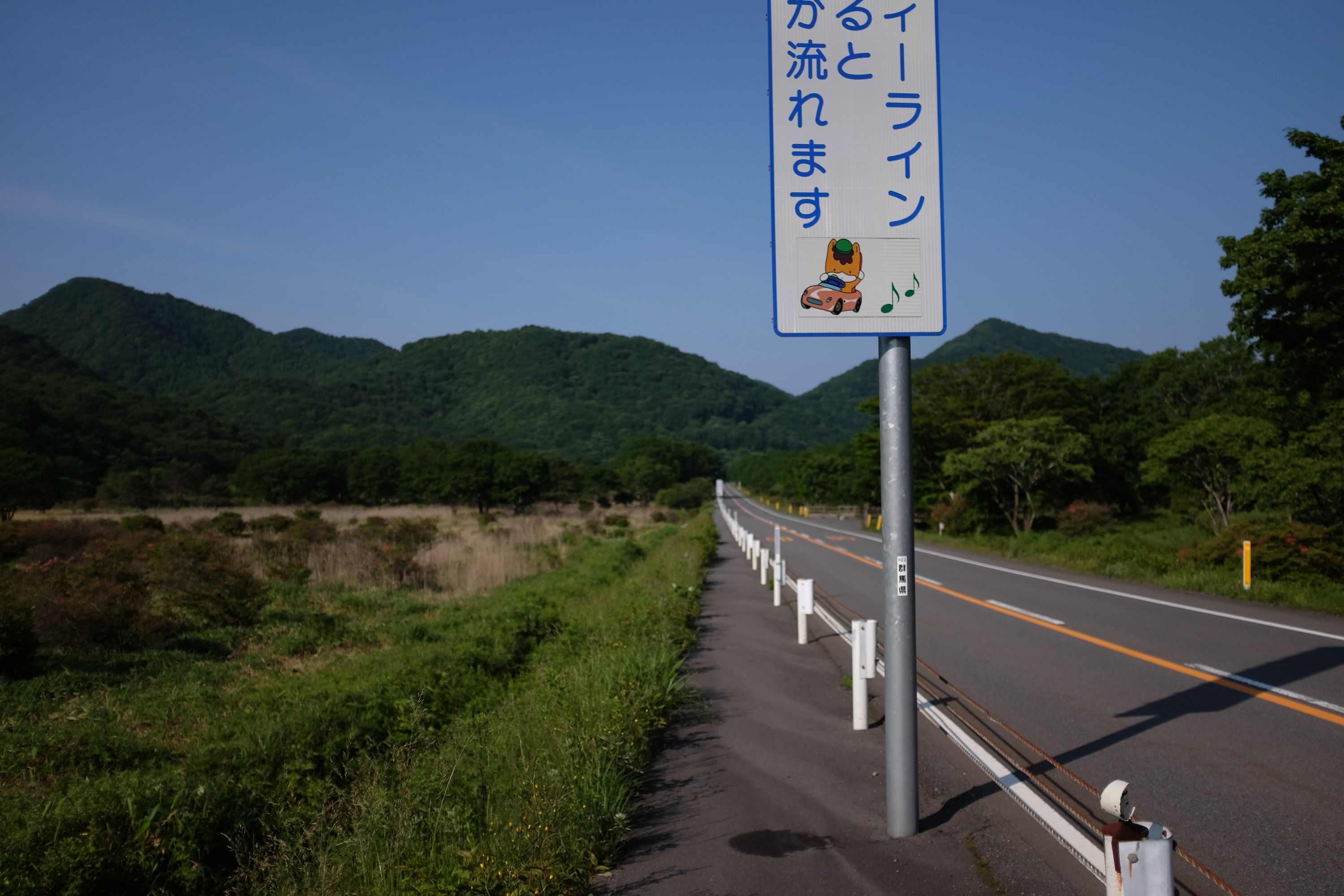 Looking back on the Melody Road, with forested hills on the horizon.