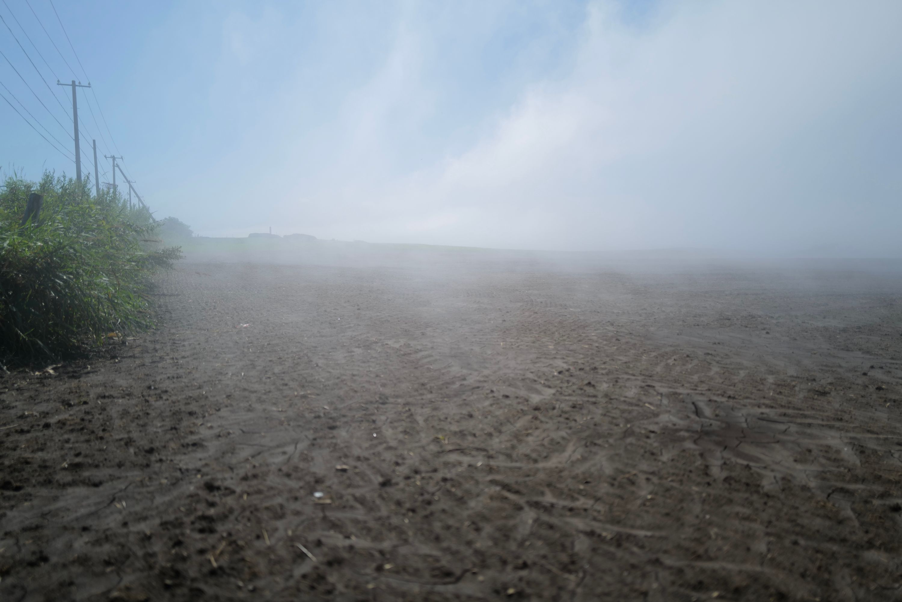 Fog creeps over a field on an otherwise clear day.