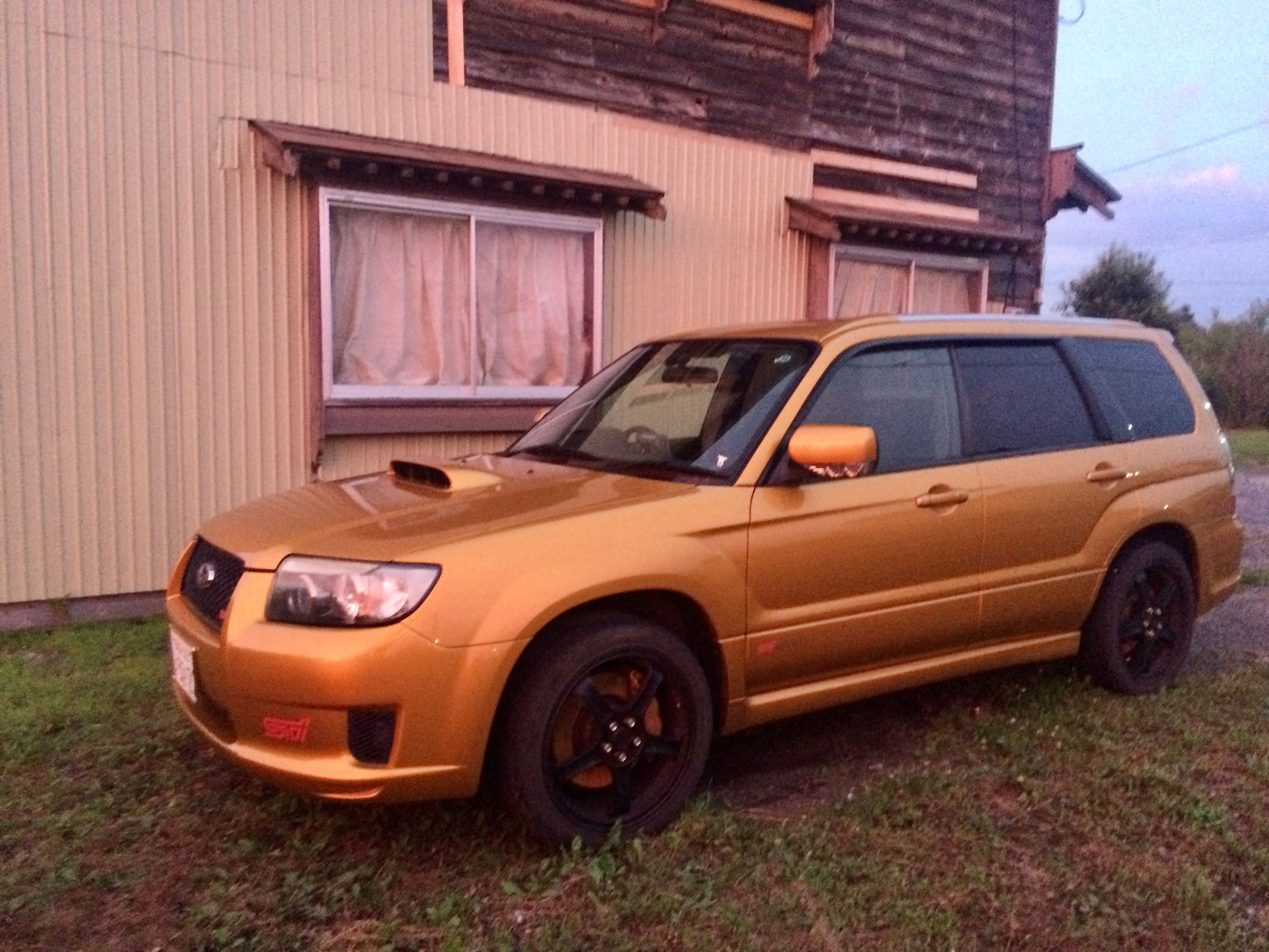 A metallic orange Subaru made even more orange by the colors of the sunset.