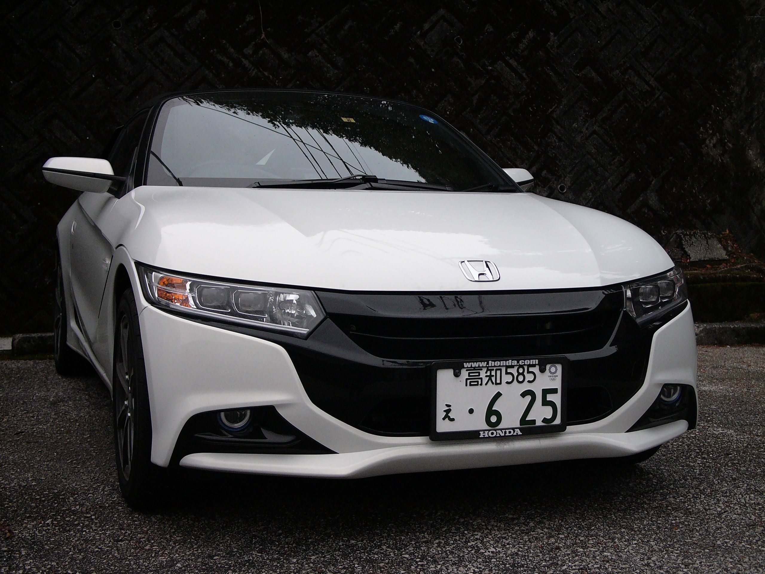 Closeup of a white Honda S660 roadster.