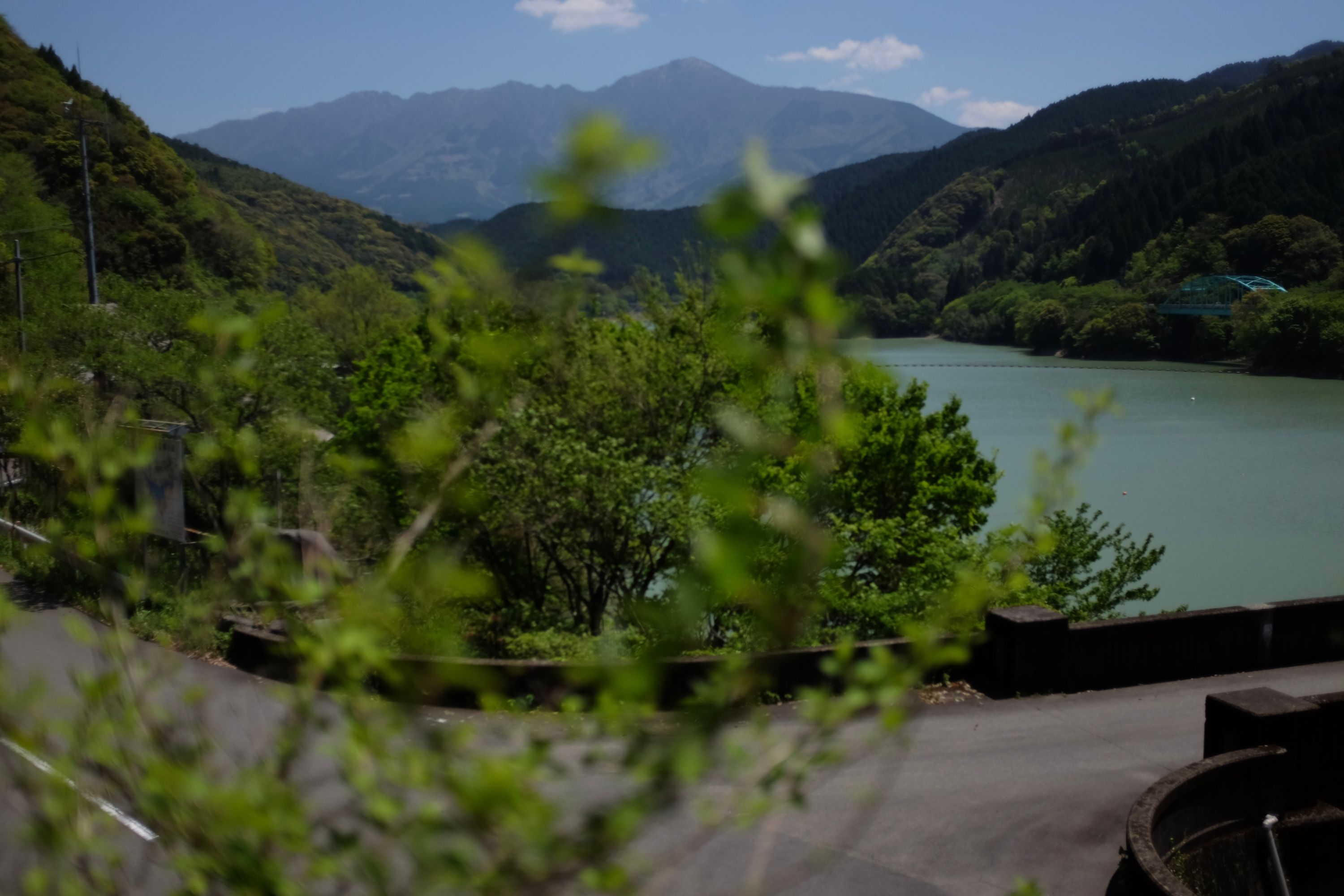 Looking out on a large mountain, Mount Ichifusa, across an artificial lake surrounded by forested hills.