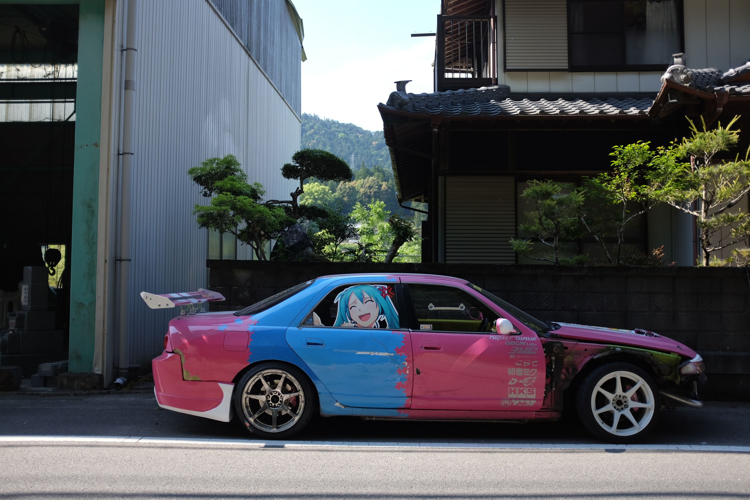 The car parked in front of a Japanese house.