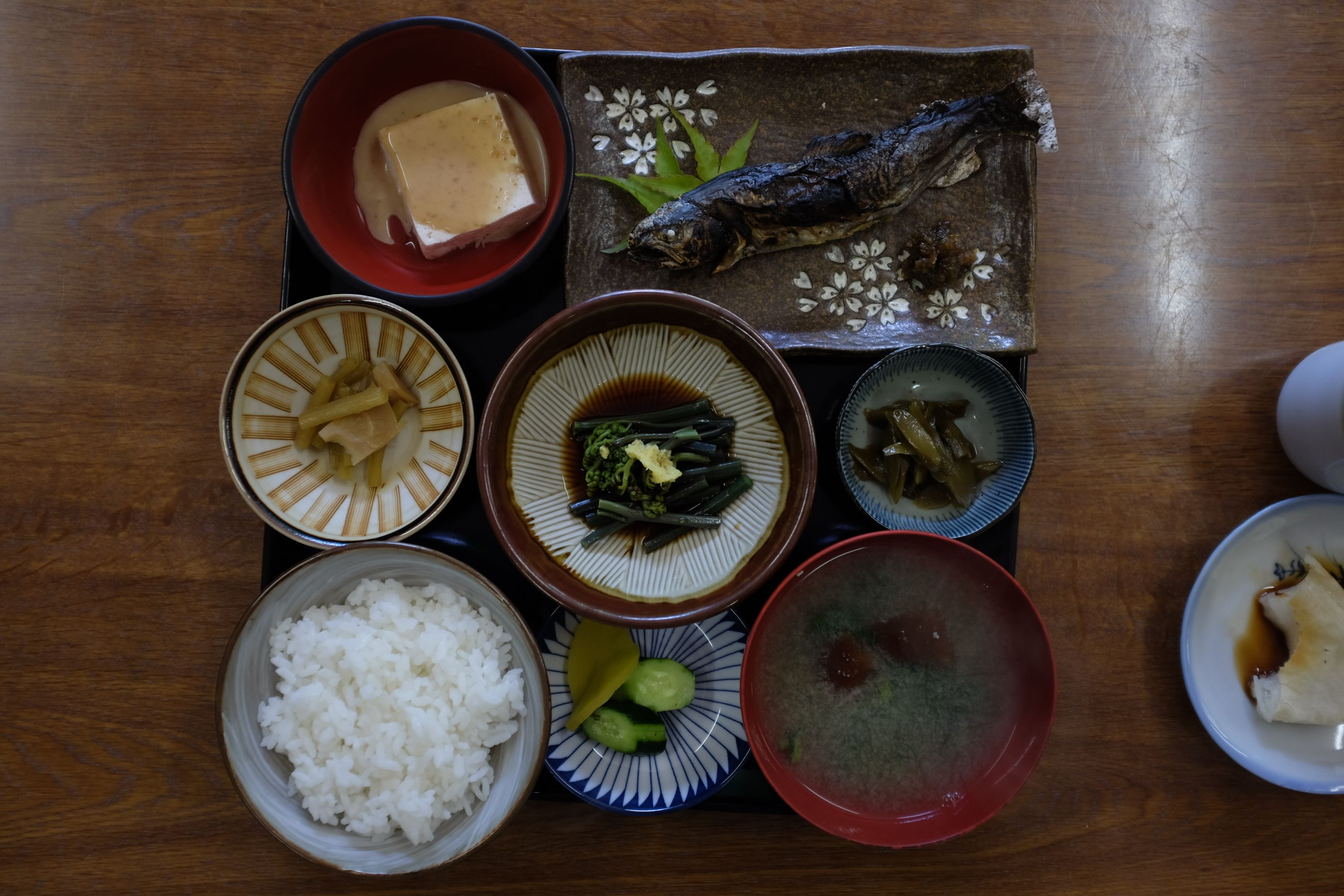 A Japanese lunch set of grilled trout, rice, miso soup, and various side dishes.