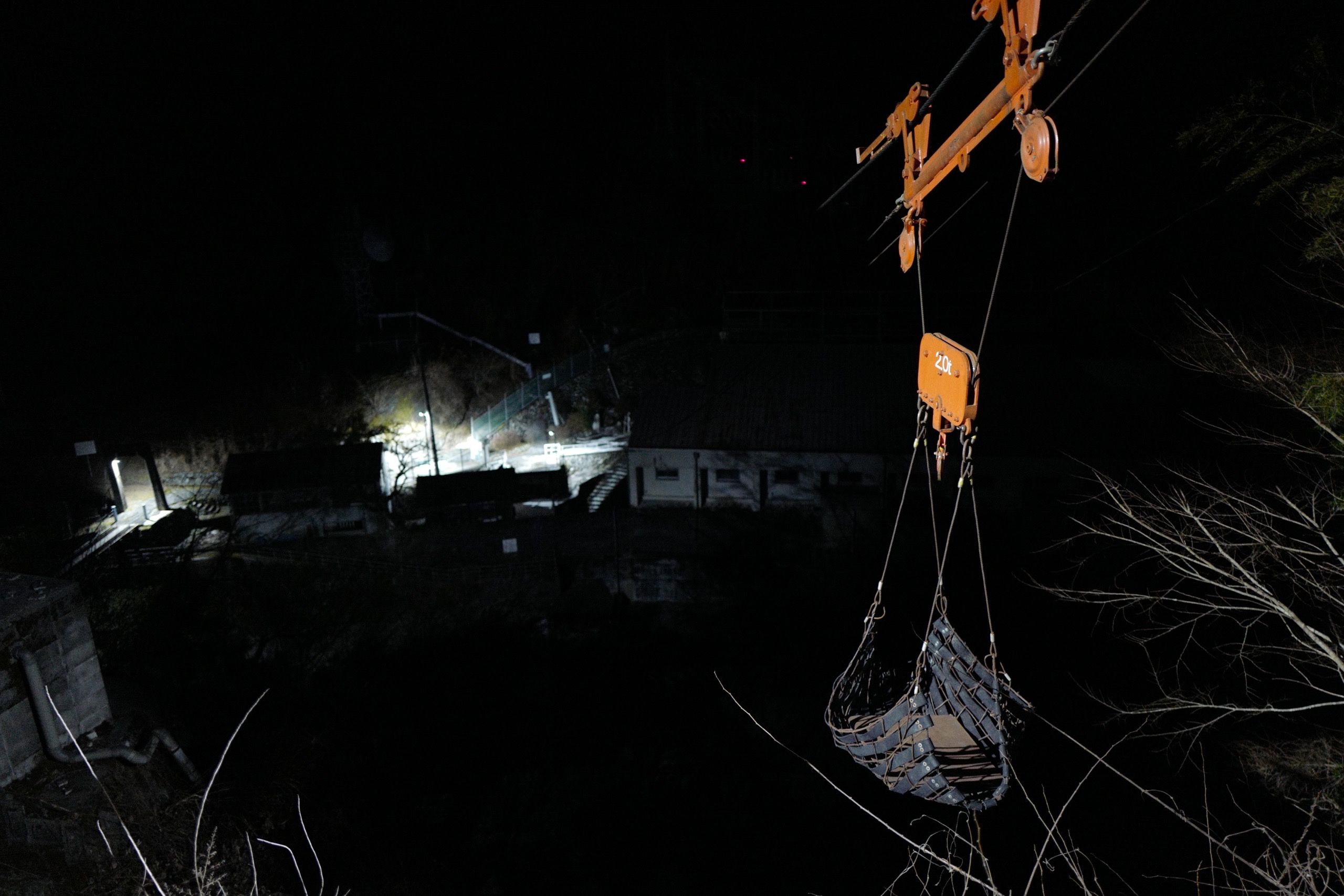 A sling on a system of cable suspended above a dark river in the night.