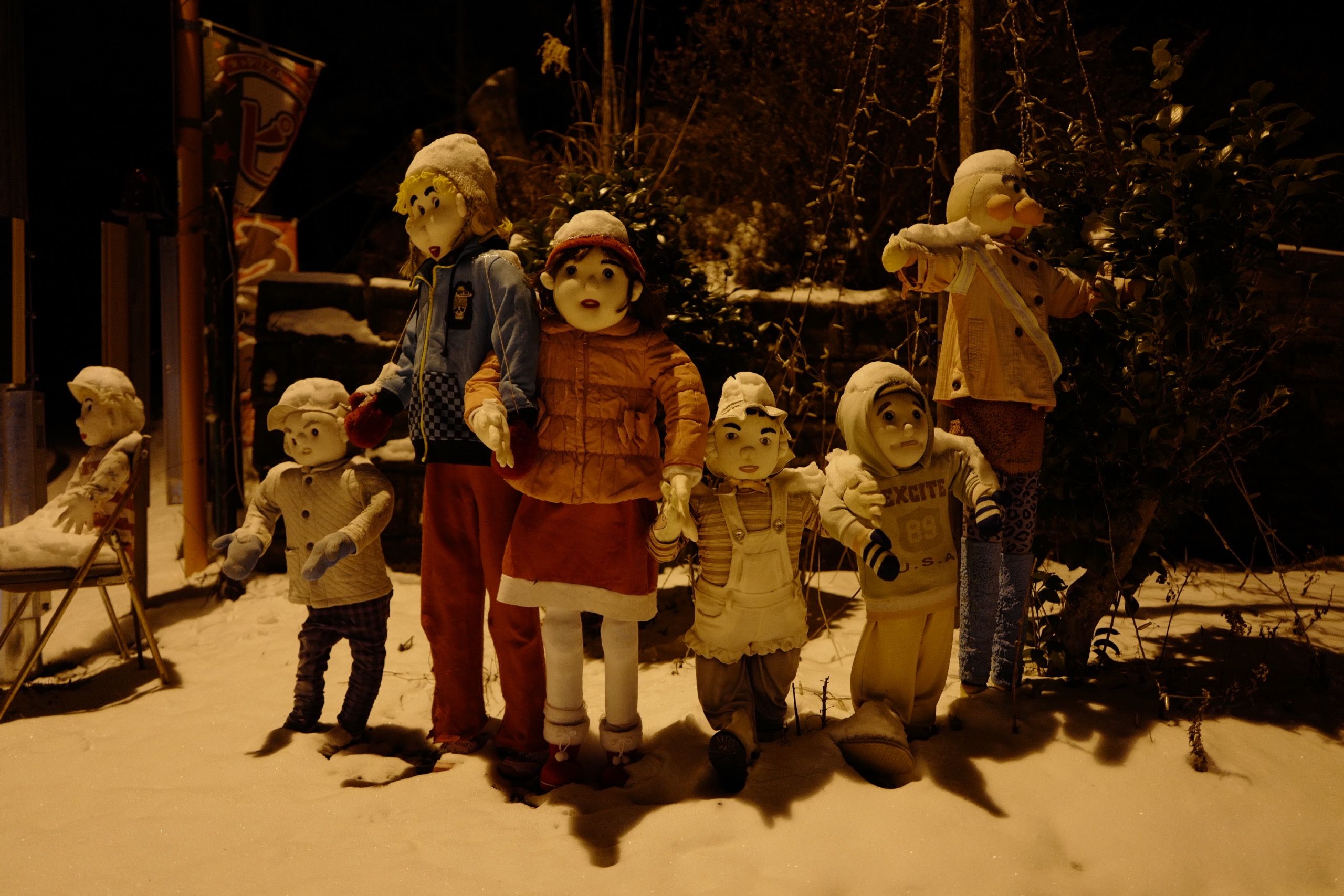 Another group of the dolls. Most of them are children, and they stand in the snow.