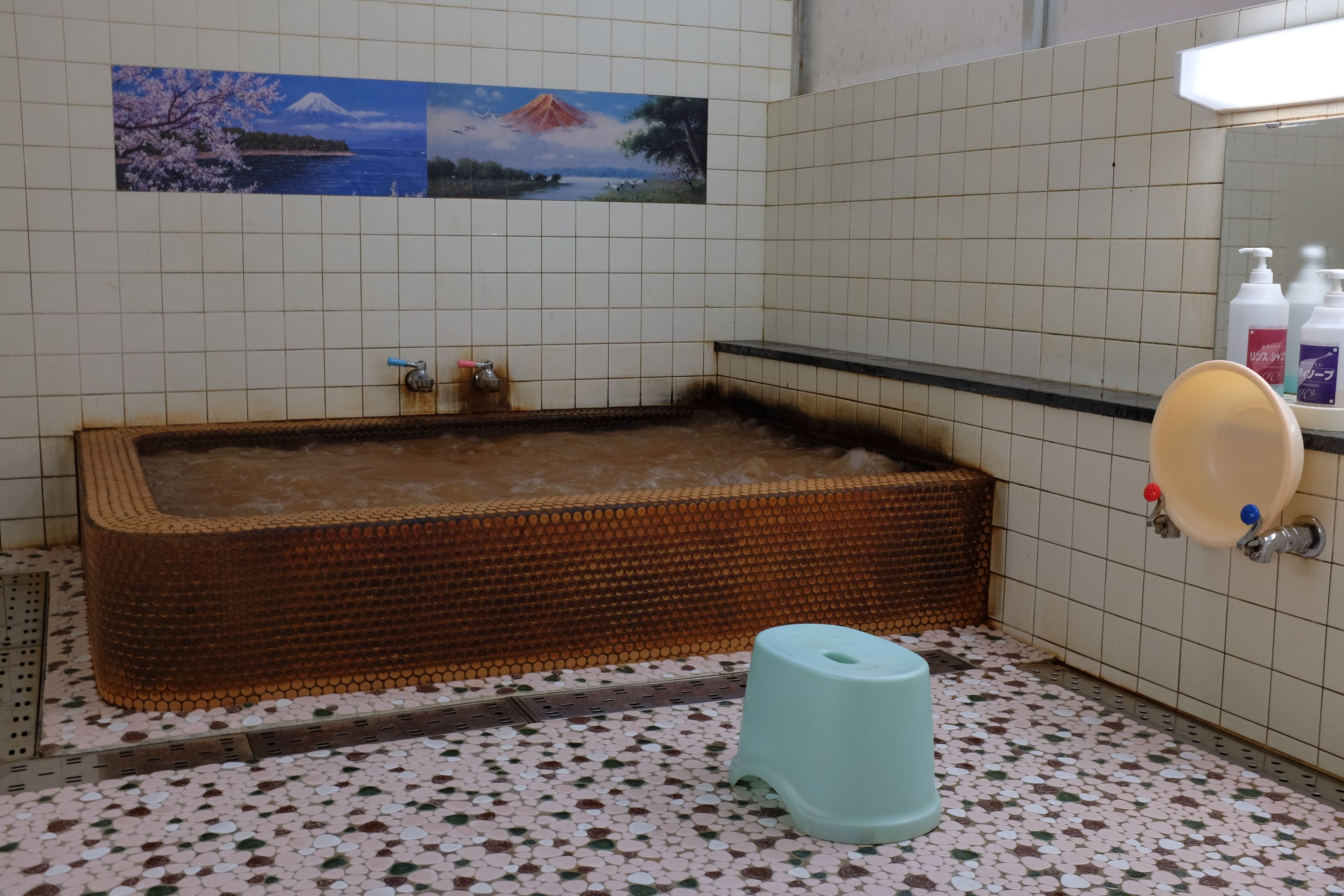 The mineral-stained tub of a traditional Japanese bathhouse.