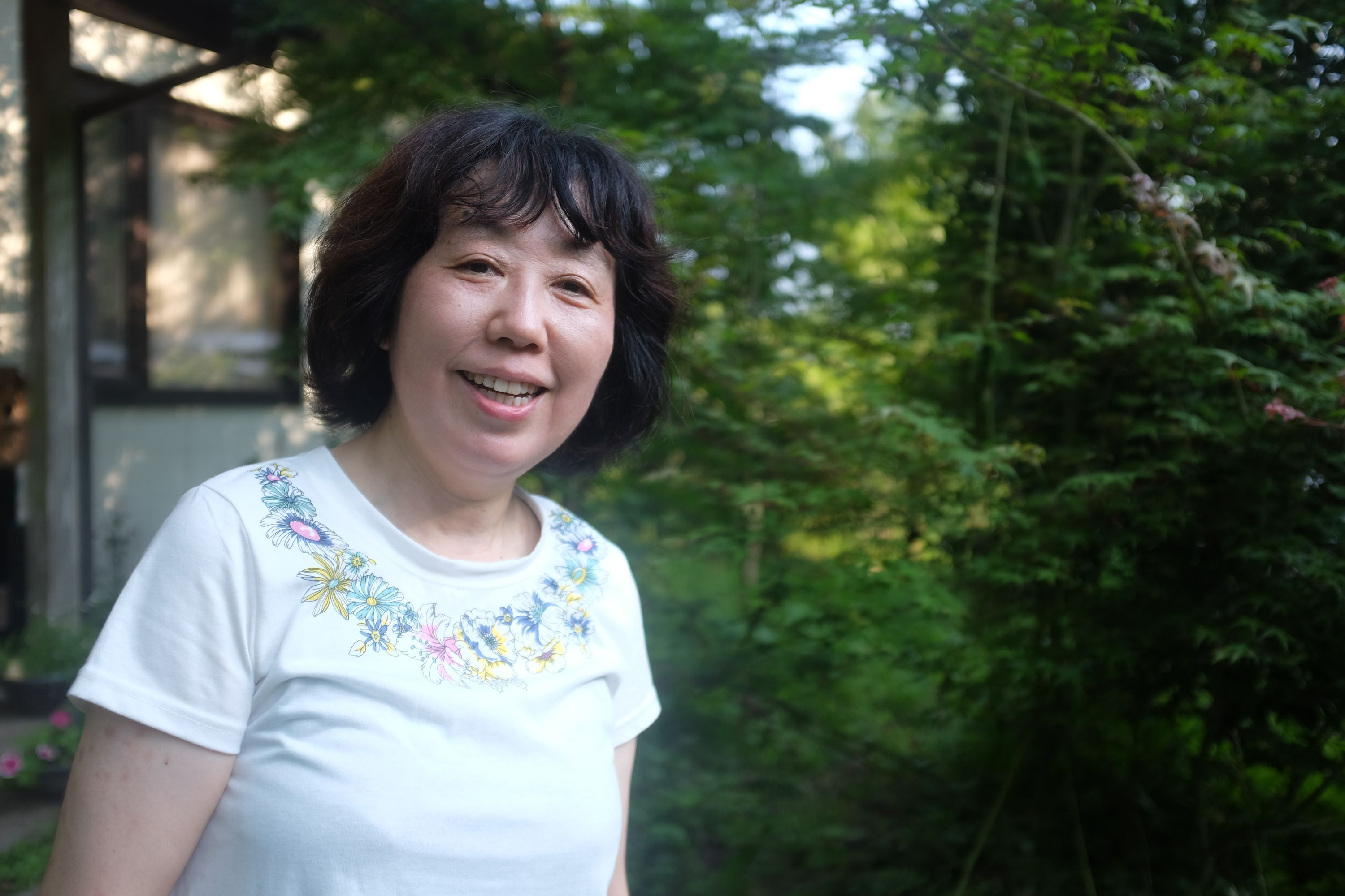 A Japanese woman, Horigome Kaoru, the owner of the cattle, smiles into the camera.