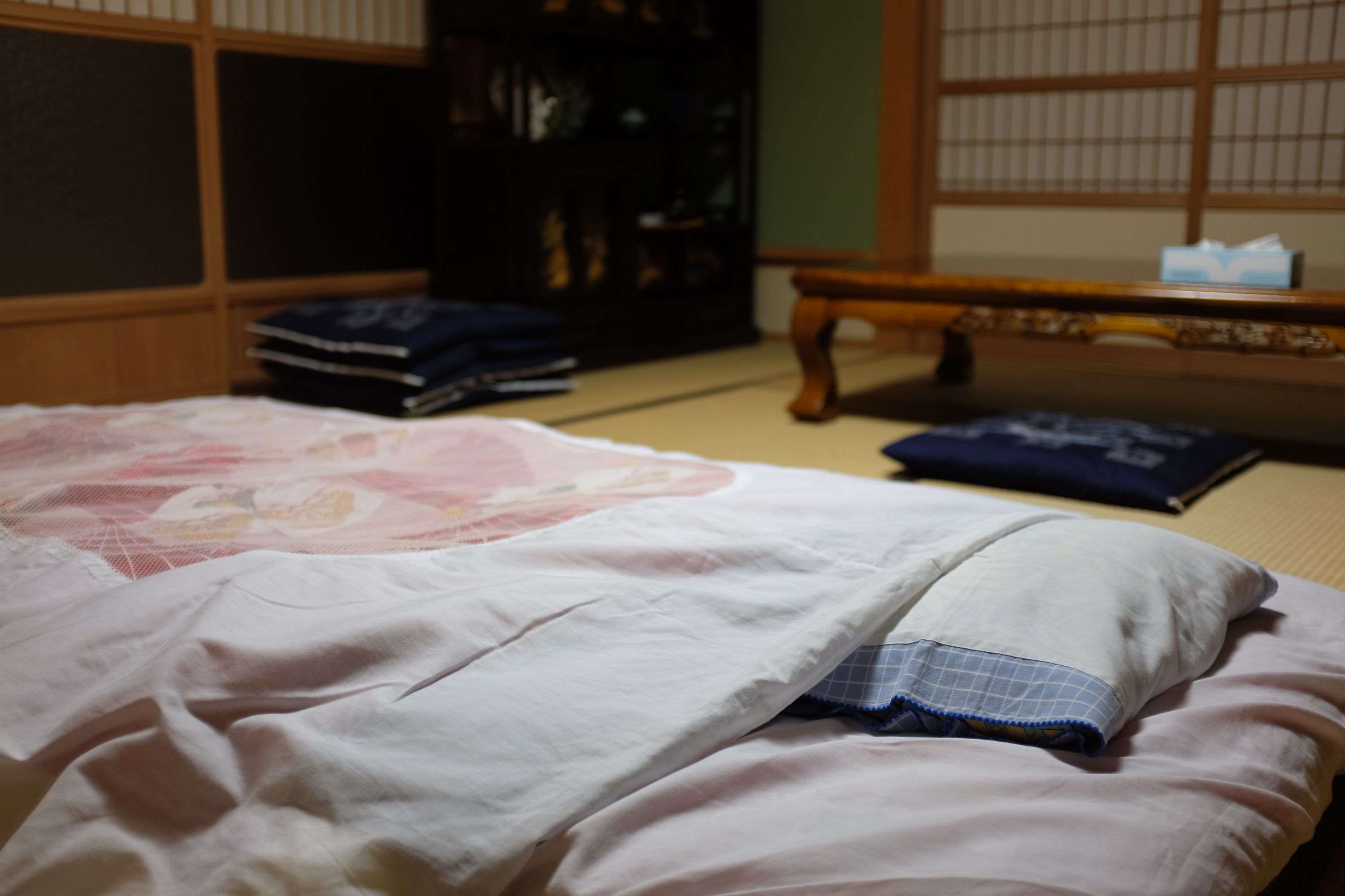 A Japanese futon bed laid out on the floor of a traditional Japanese room.