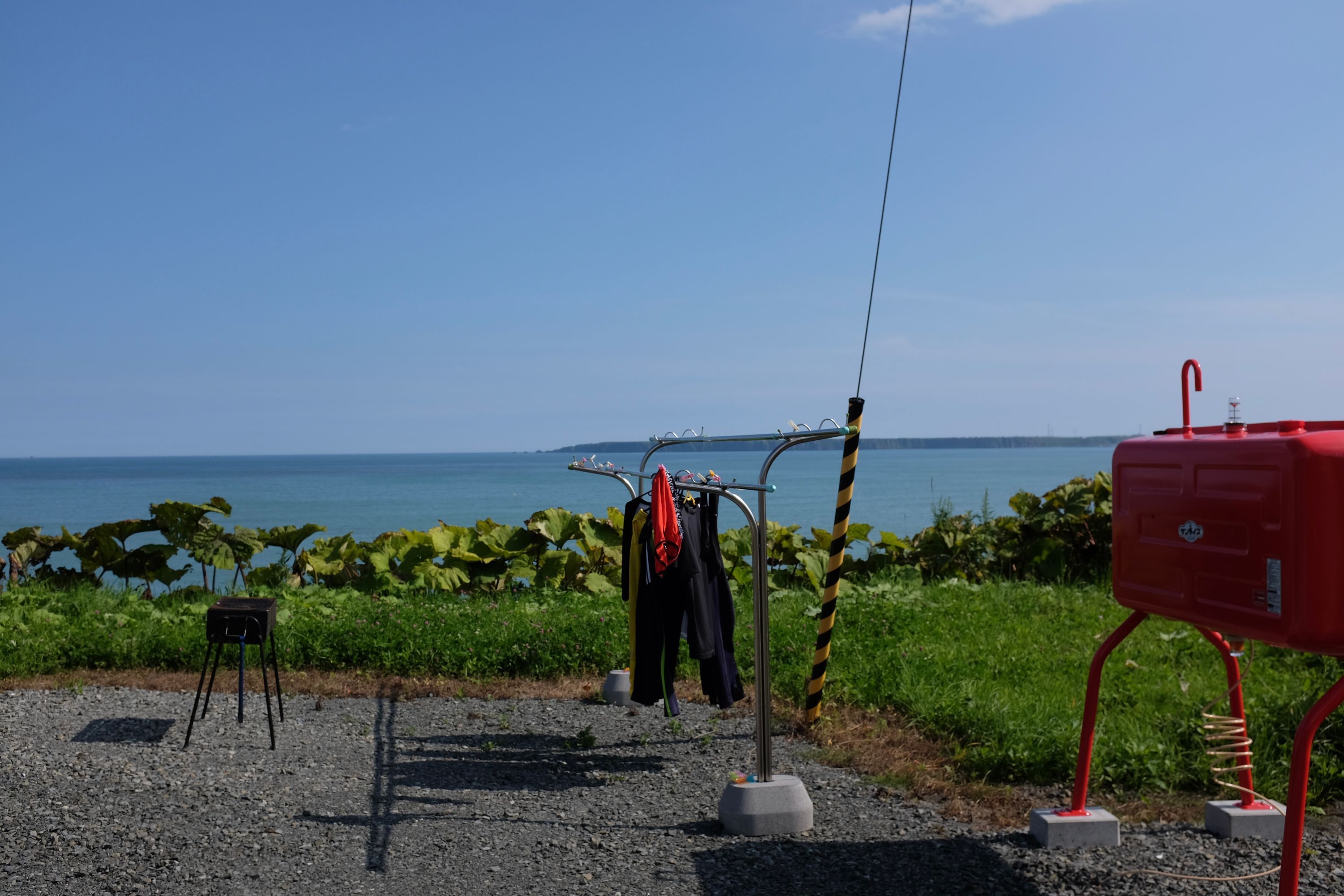 Clothes drying on a rack with a view of the ocean.