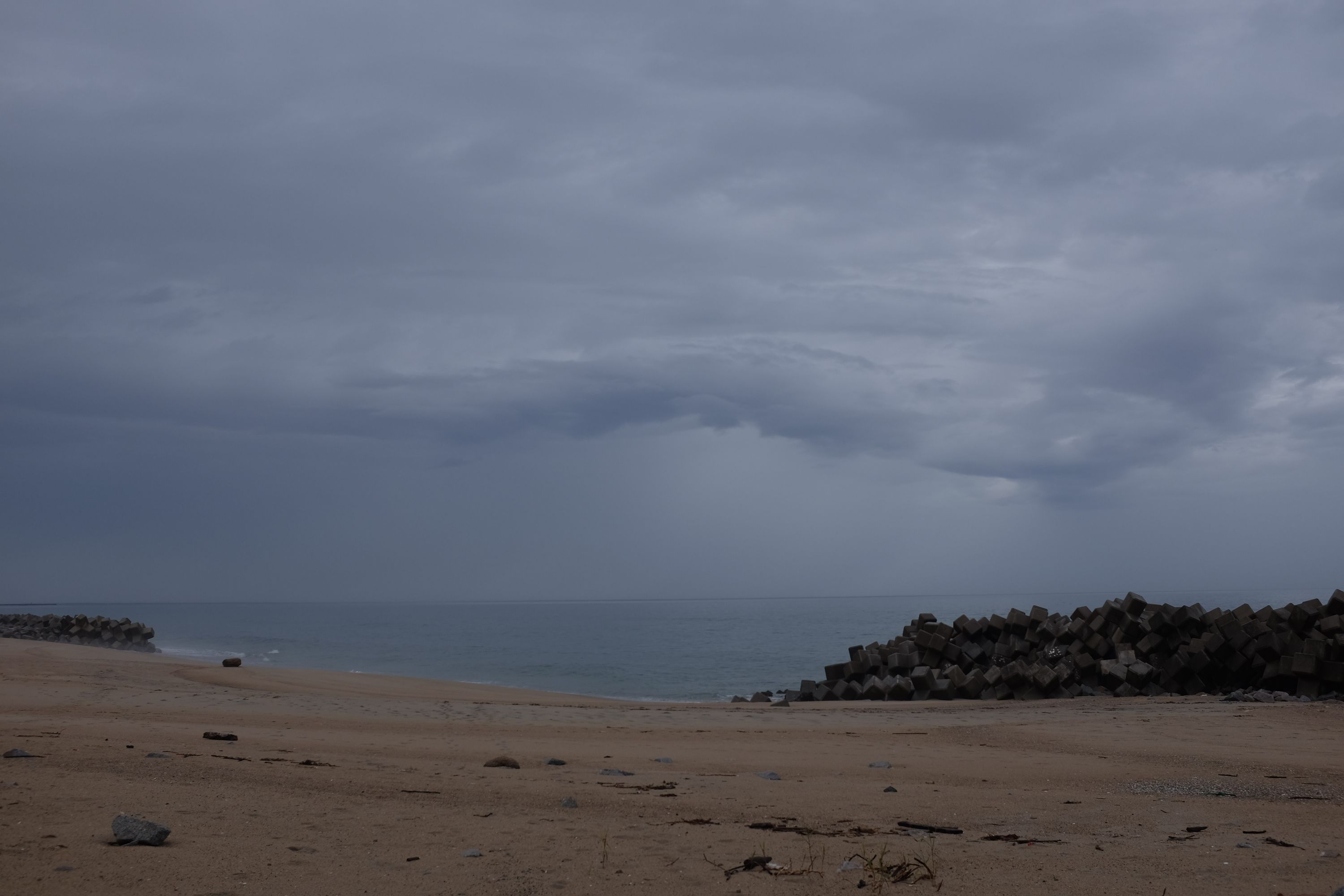 Swirling grey clouds above the beach.