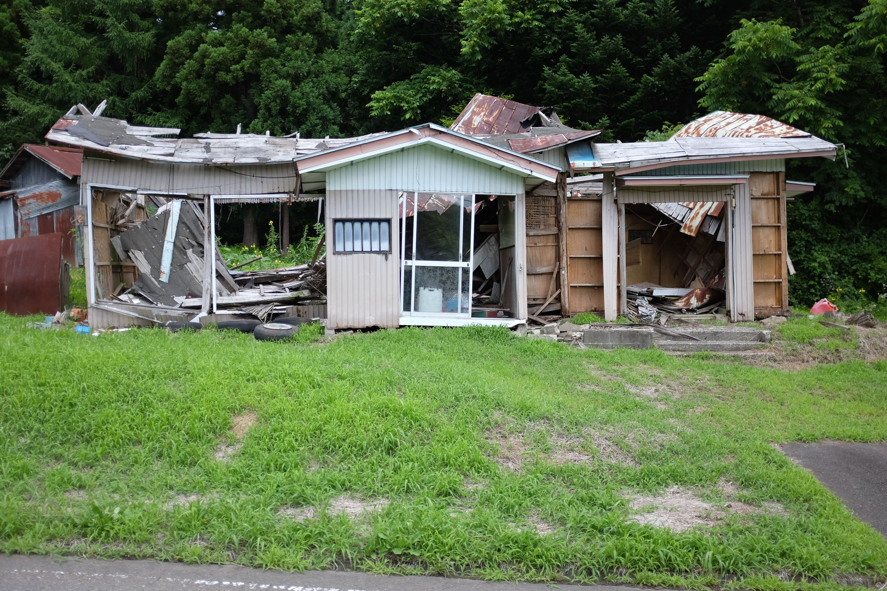 A derelict house with most of its walls missing and its roof badly damaged.